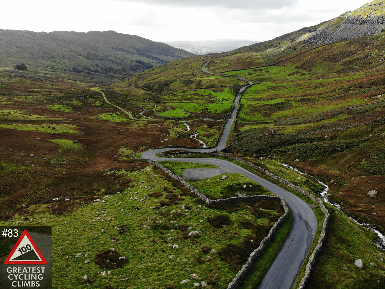 Cycling Kirkstone Pass #83 Simon Warren 100 Greatest Cycling Climbs  - aerial drone photo, roadway, hillside, pass, 100 Greatest Cycling Climbs logo