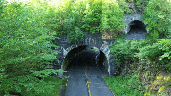 Climbing Mt. Mitchell - arial drone view of cyclist climbing into tunnel