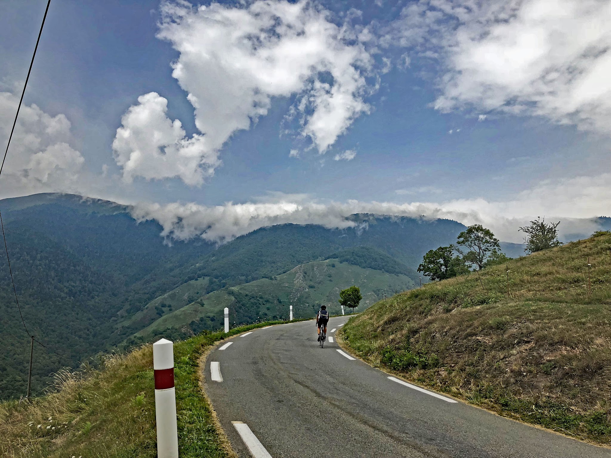cyclist rides on one lane mountain roadway, Pyrenees 