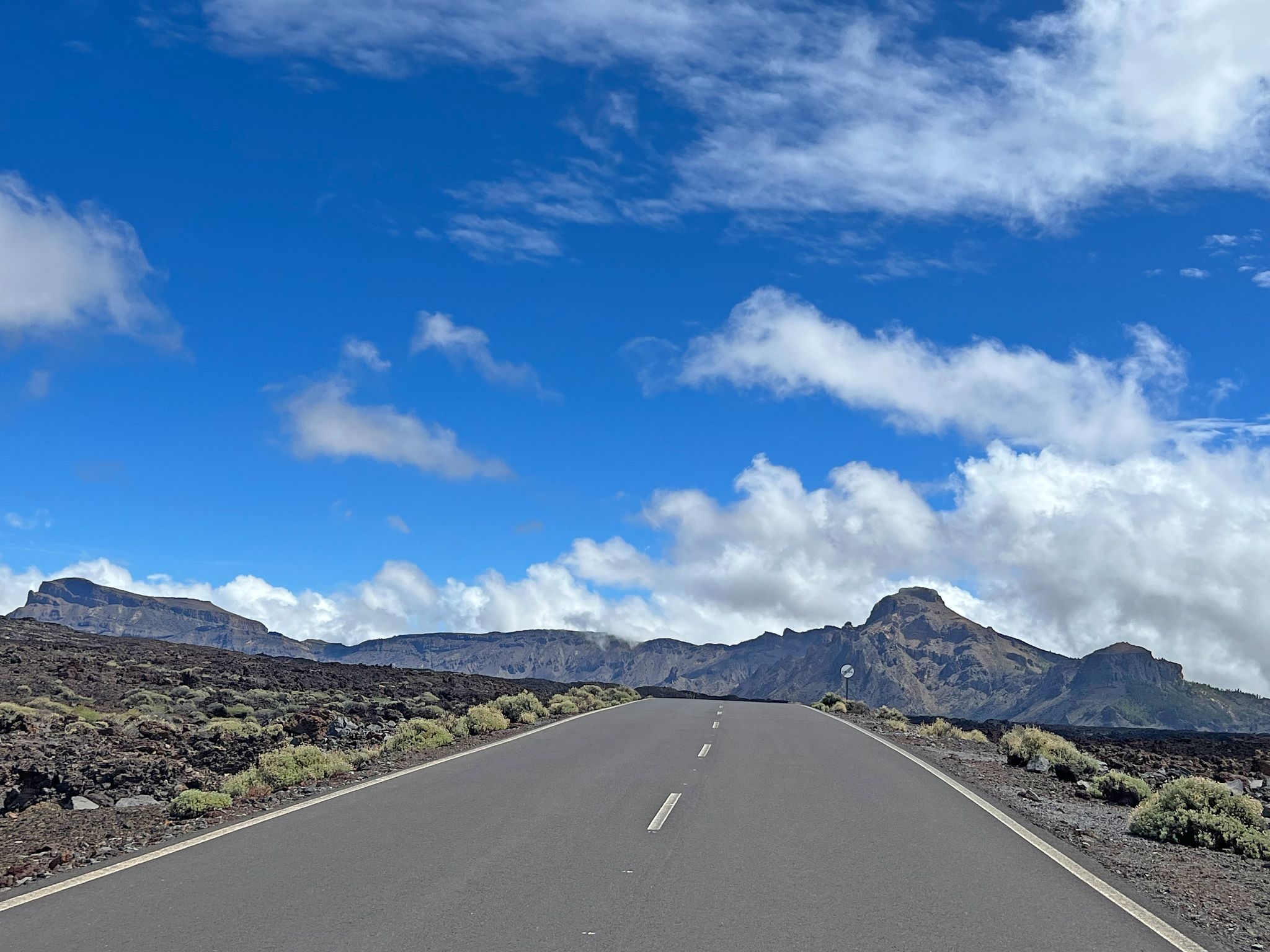 climb finish on highway TF-38, two-lane well paved highway roadway, mountain formations in distance