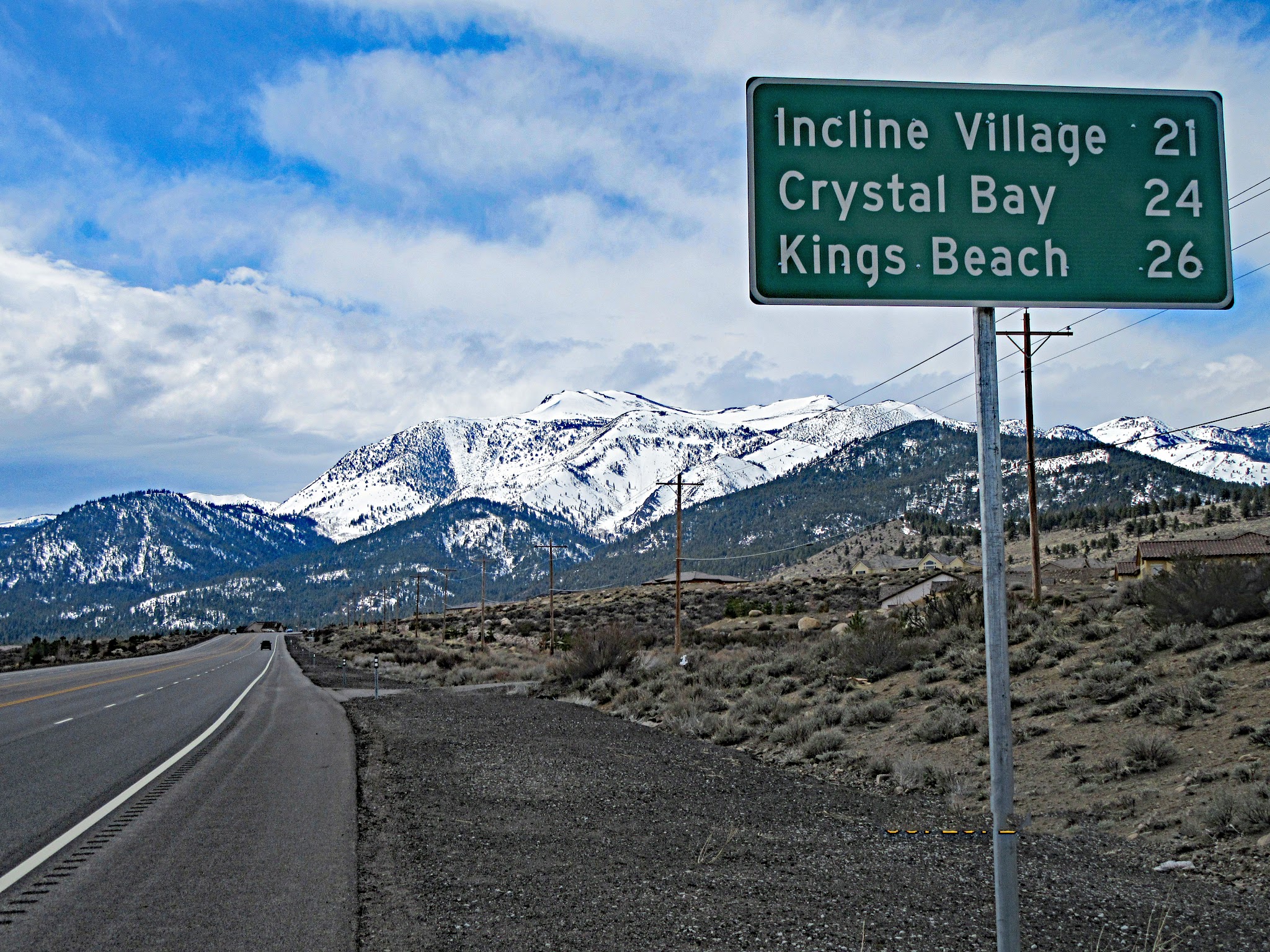 Cycling Mt. Rose East, Nevada - road sign for Incline Village, Crystal Bay, Kings Beach, snow capped mountains beyond