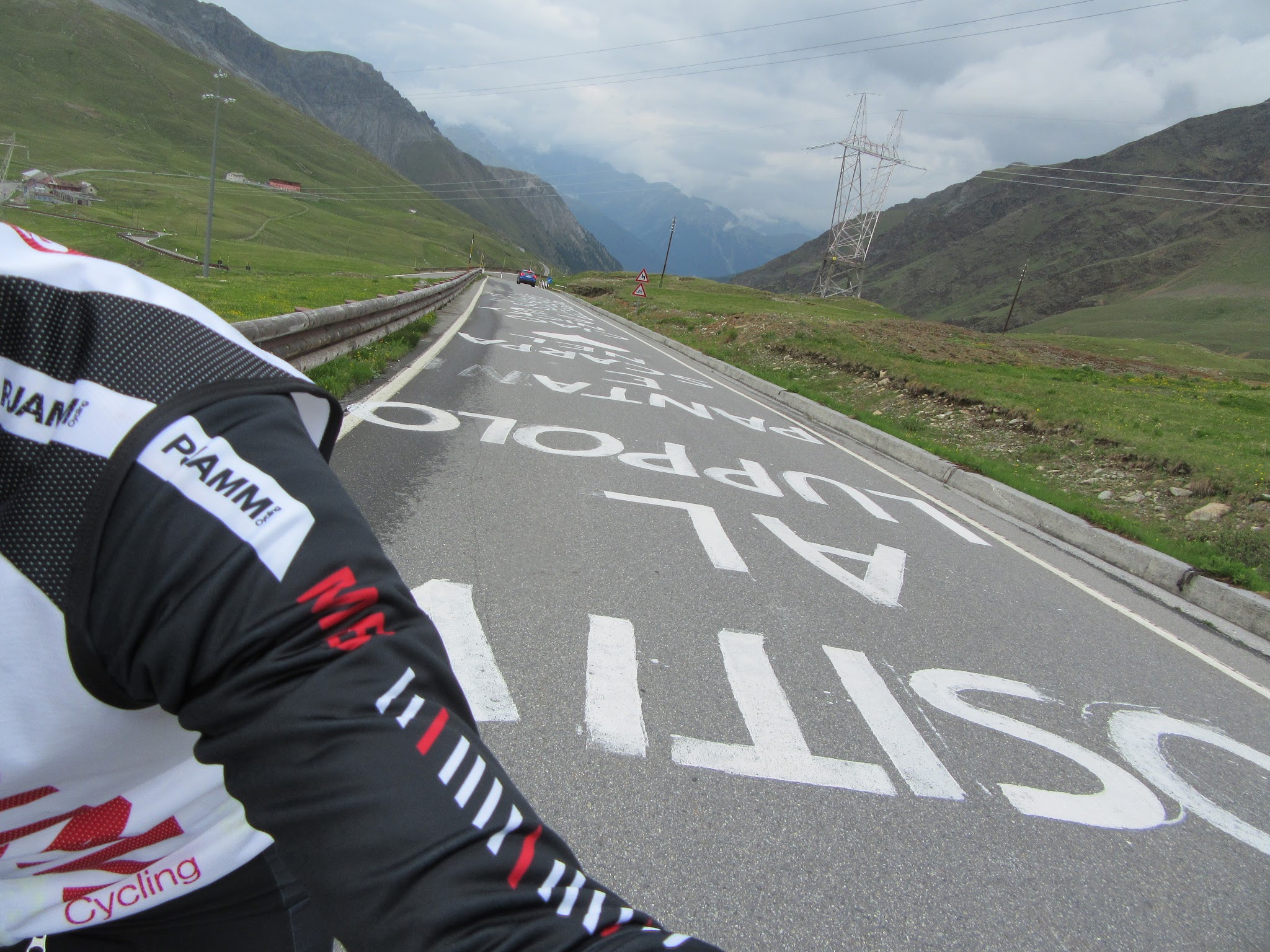 Climbing Umbrail Pass by bike to passo dello stelvio - giro d'italia signs painted on road, cyclist 