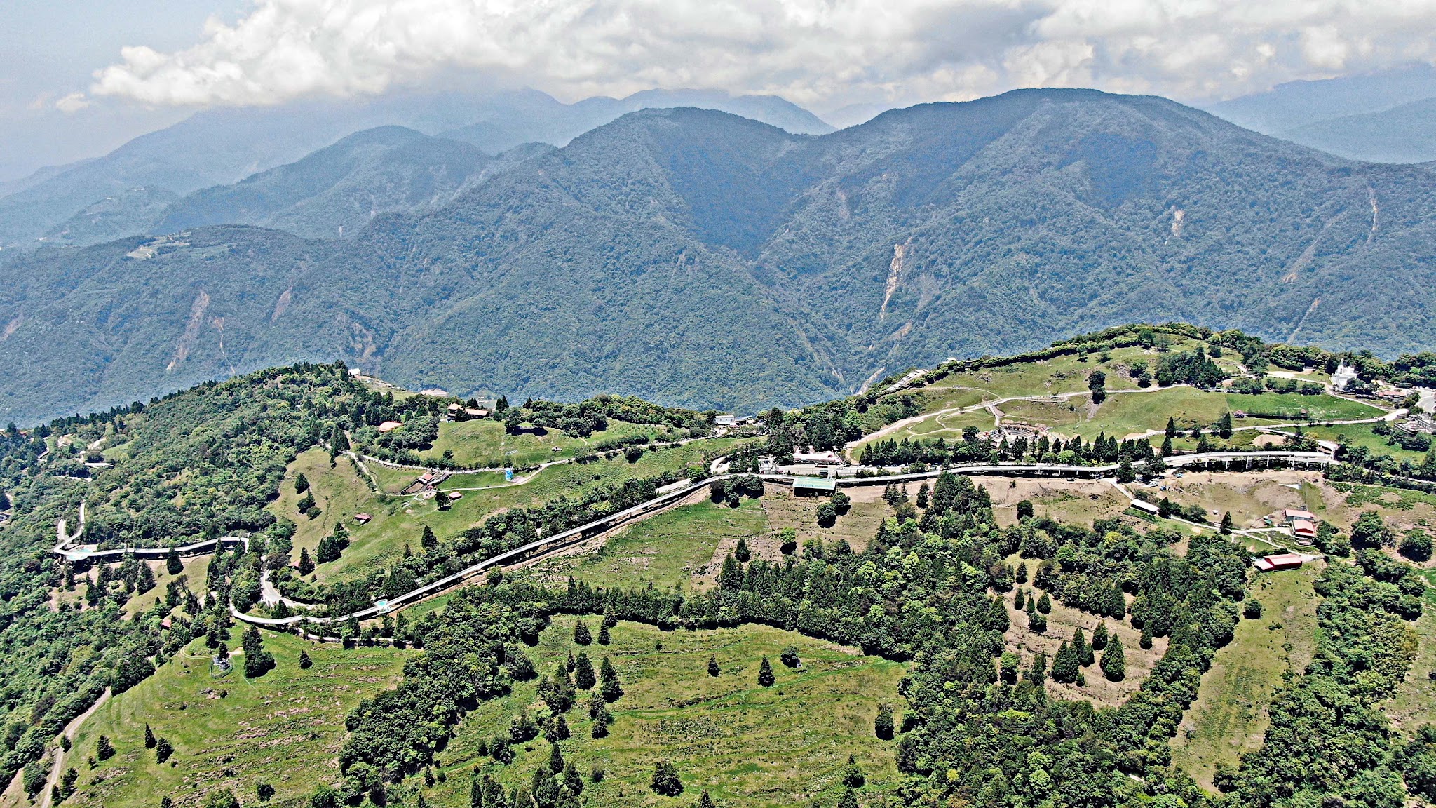 Cycling Wuling Pass West - Cingjing Skywalk from aerial drone, walkway, mountains, farm and reservoir