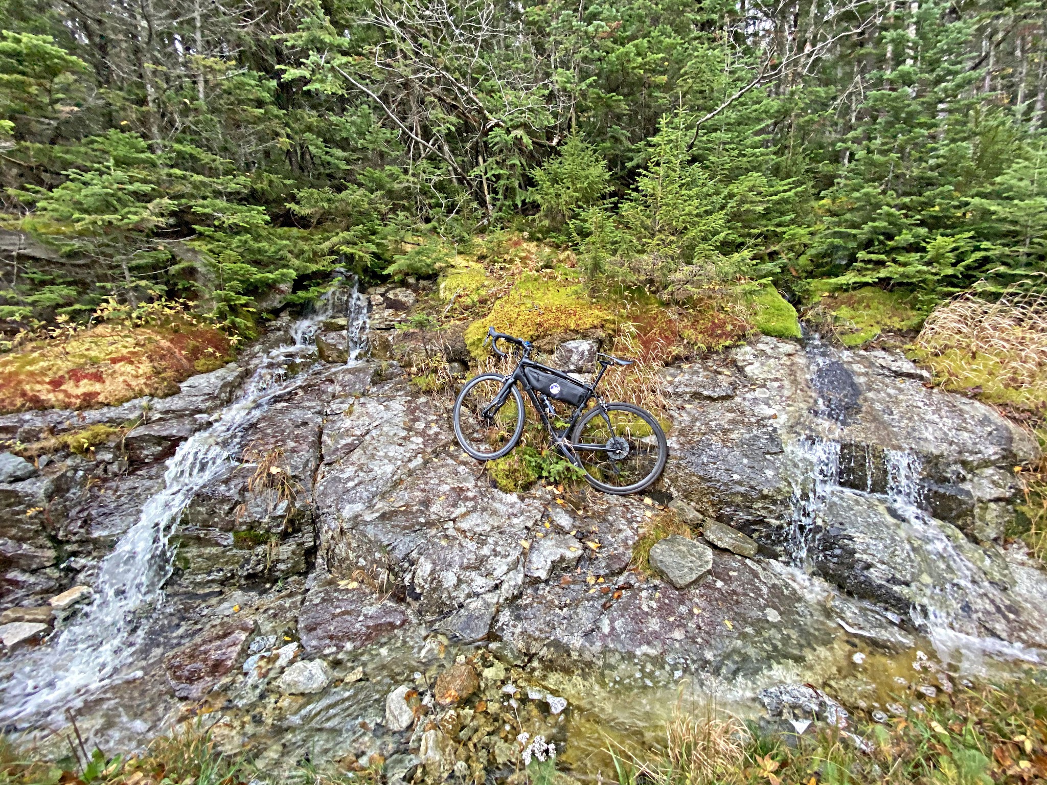 Cycling Whiteface Mountain, New York - bike parked on rocks next to stream along roadside