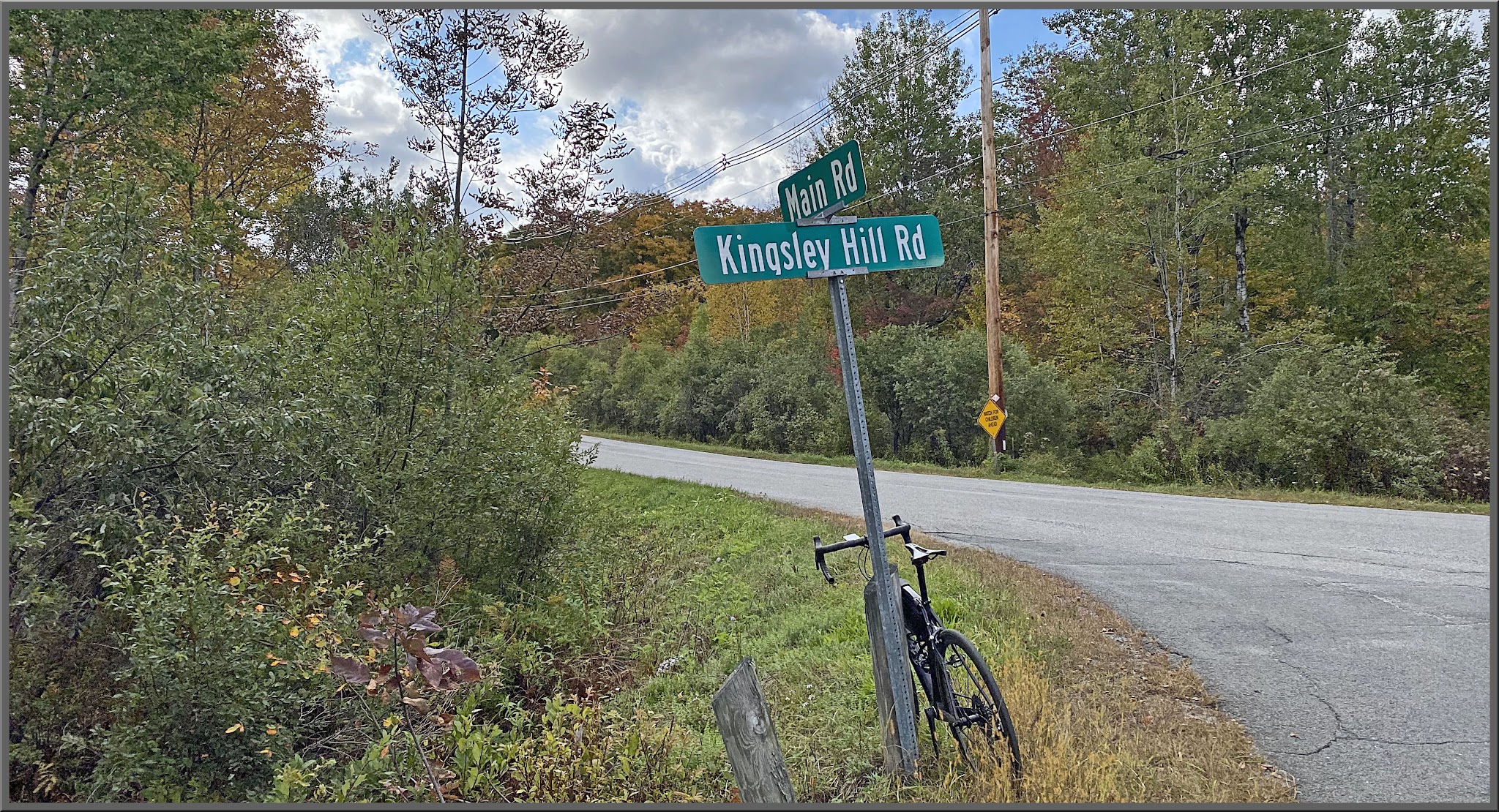 Cycling Kinsley Hill Road, Massachusetts - bike parked against street sign at intersection of Kingsley Hill Road and Main Road
