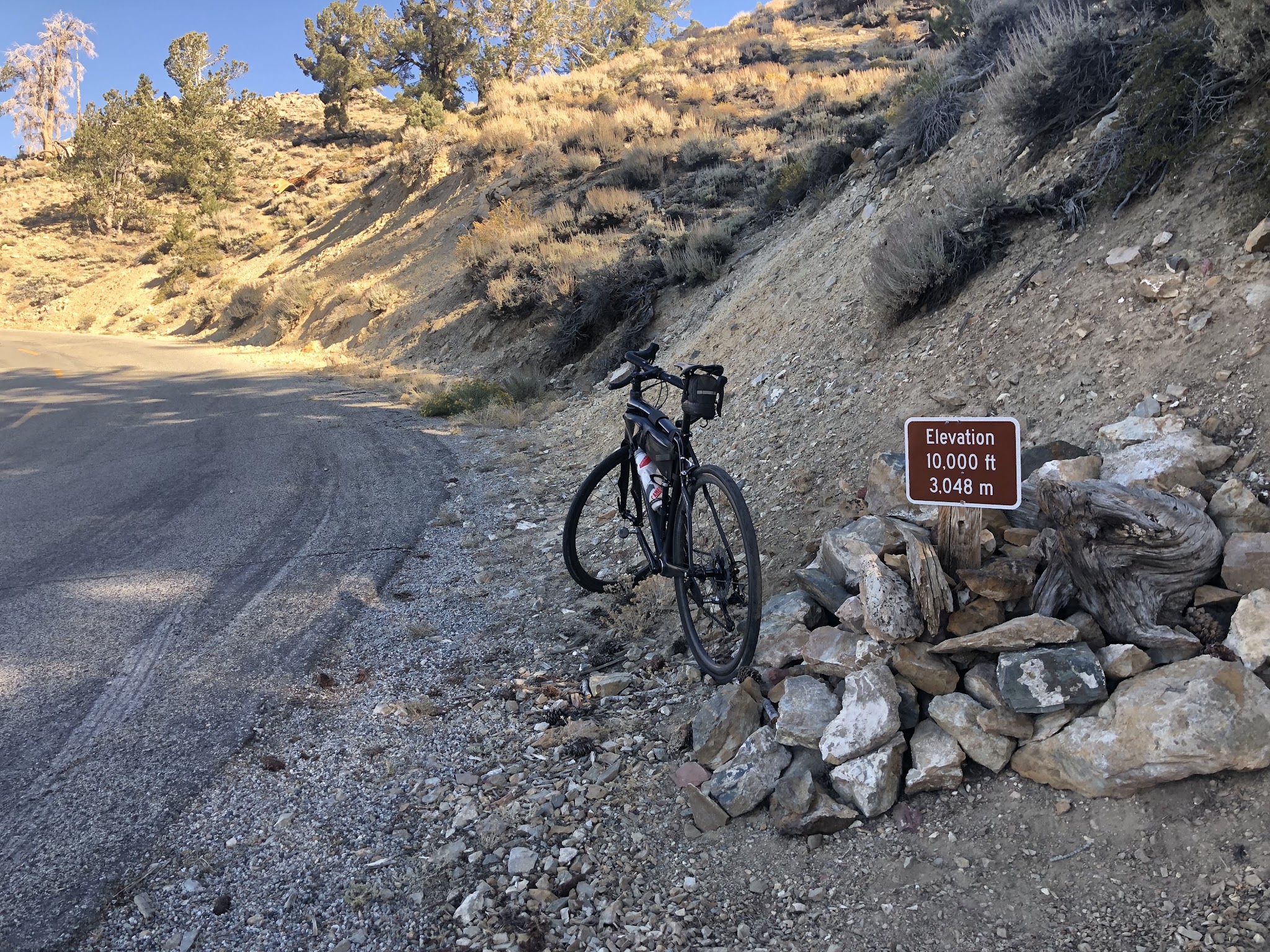 Climbing White Mountain Road by bike - 10,000' elevation sign, road, clouds