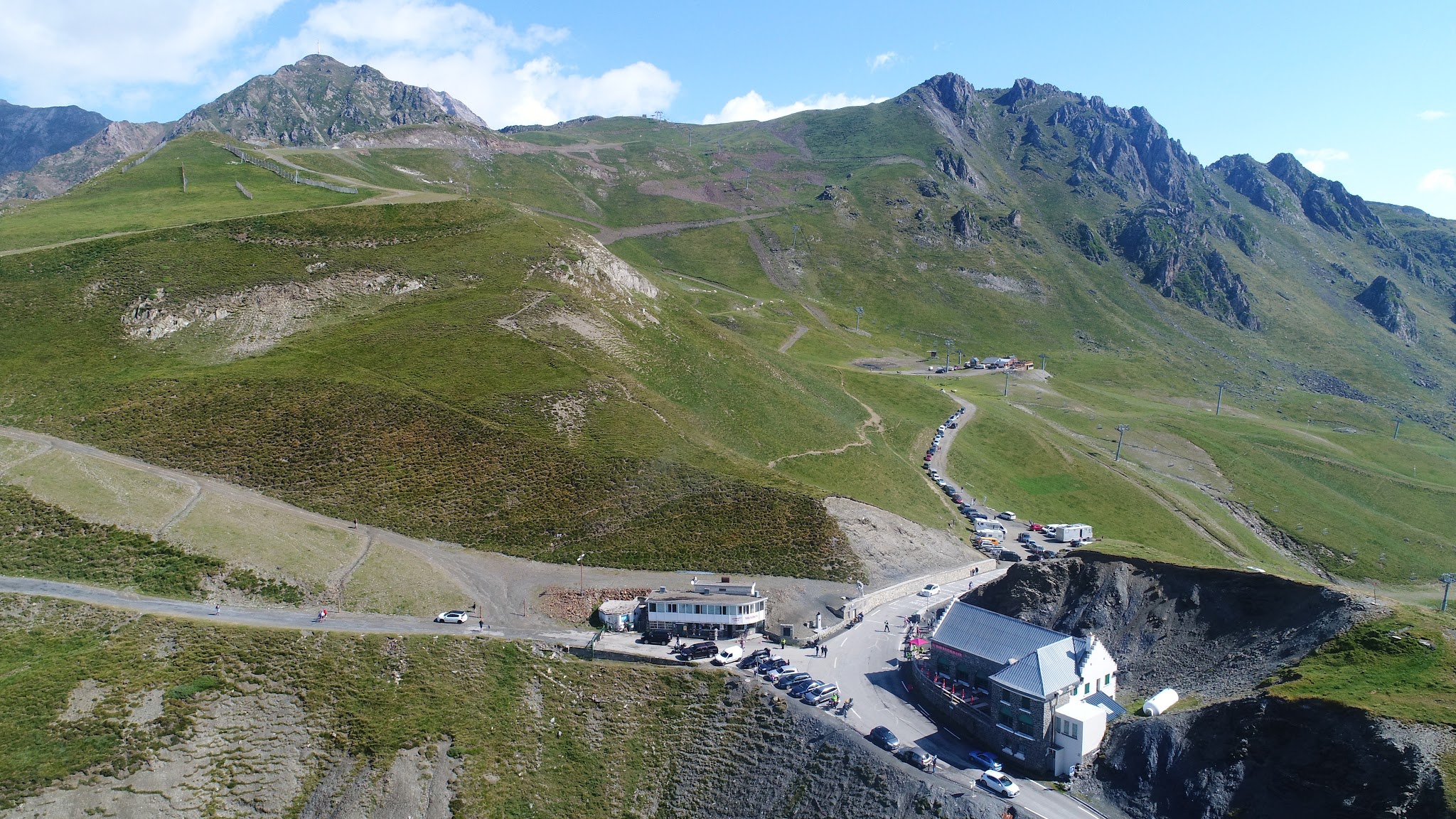 Climbing Col du Tourmalet by bike - drone aerial photo of col - cyclists, restaurant, statue, Le Géant, col sign