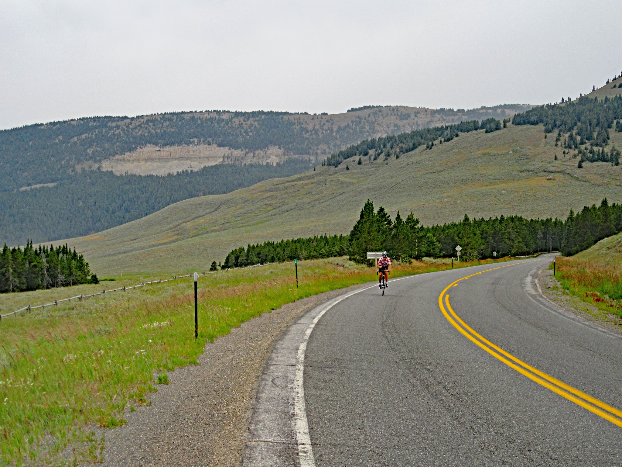 Cycling Granite Pass West (Highway 14), Wyoming - cyclist riding on curved portion of two-lane roadway