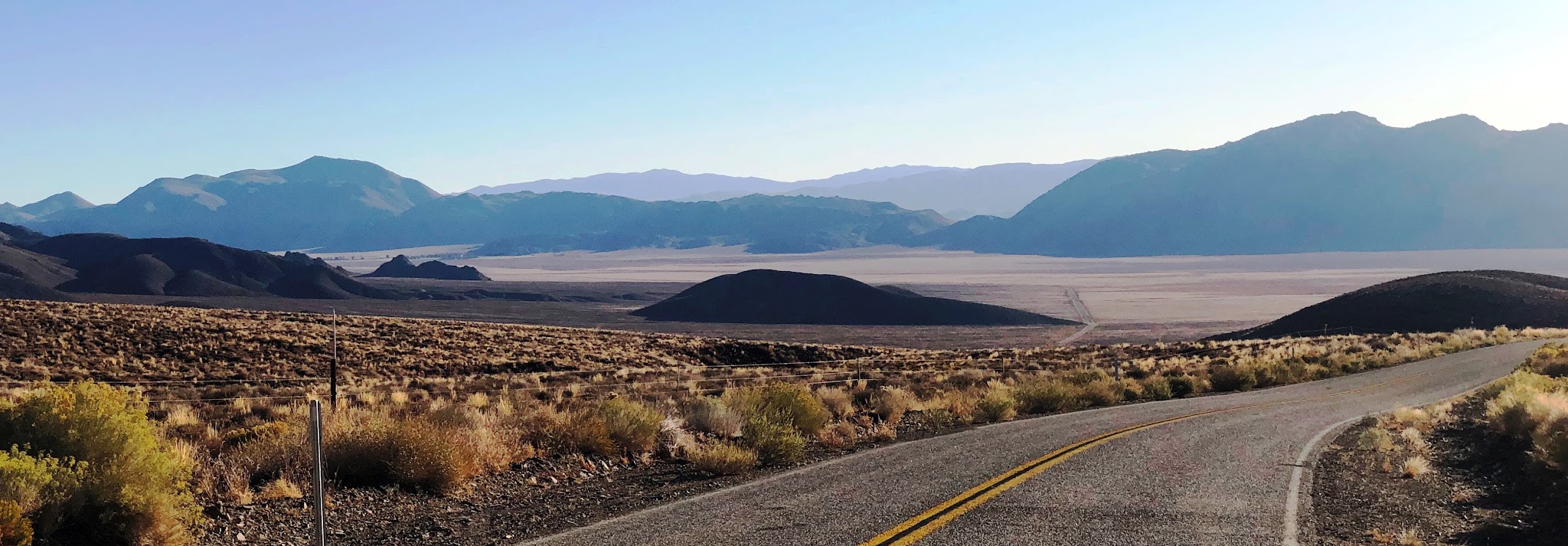 Cycling White Mountain - roadway, meadow, mountains and clouds
