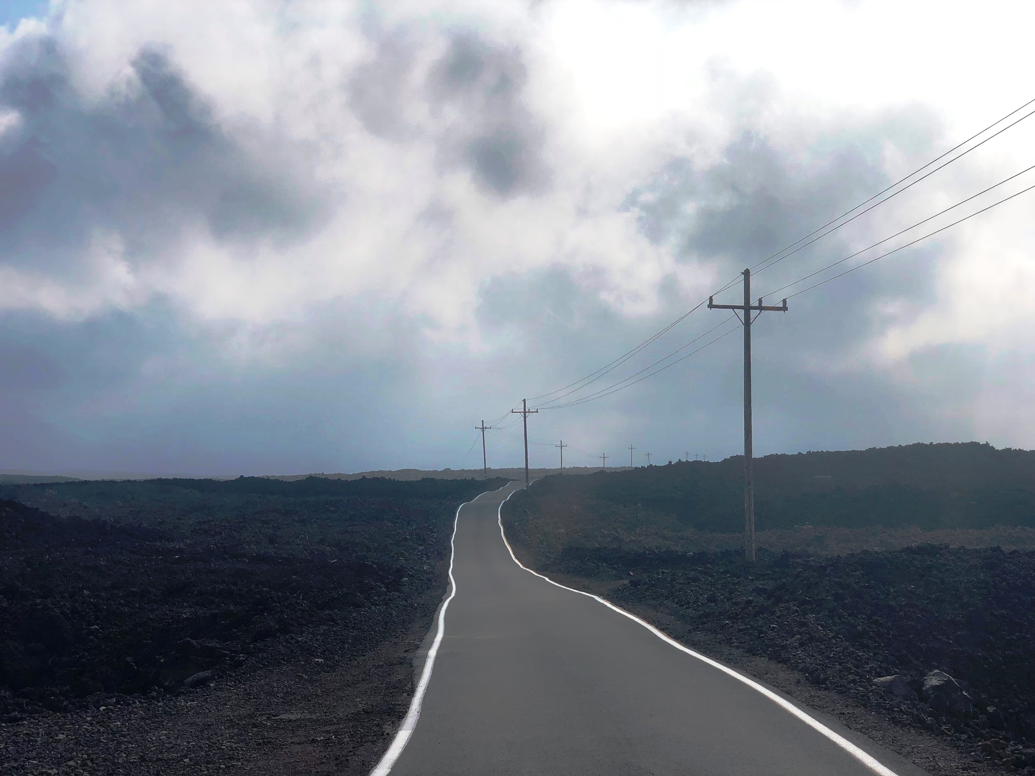 Climbing Mauna Loa by bike - Mauna Loa Observatory Road - roadway and telephone poles with lava field