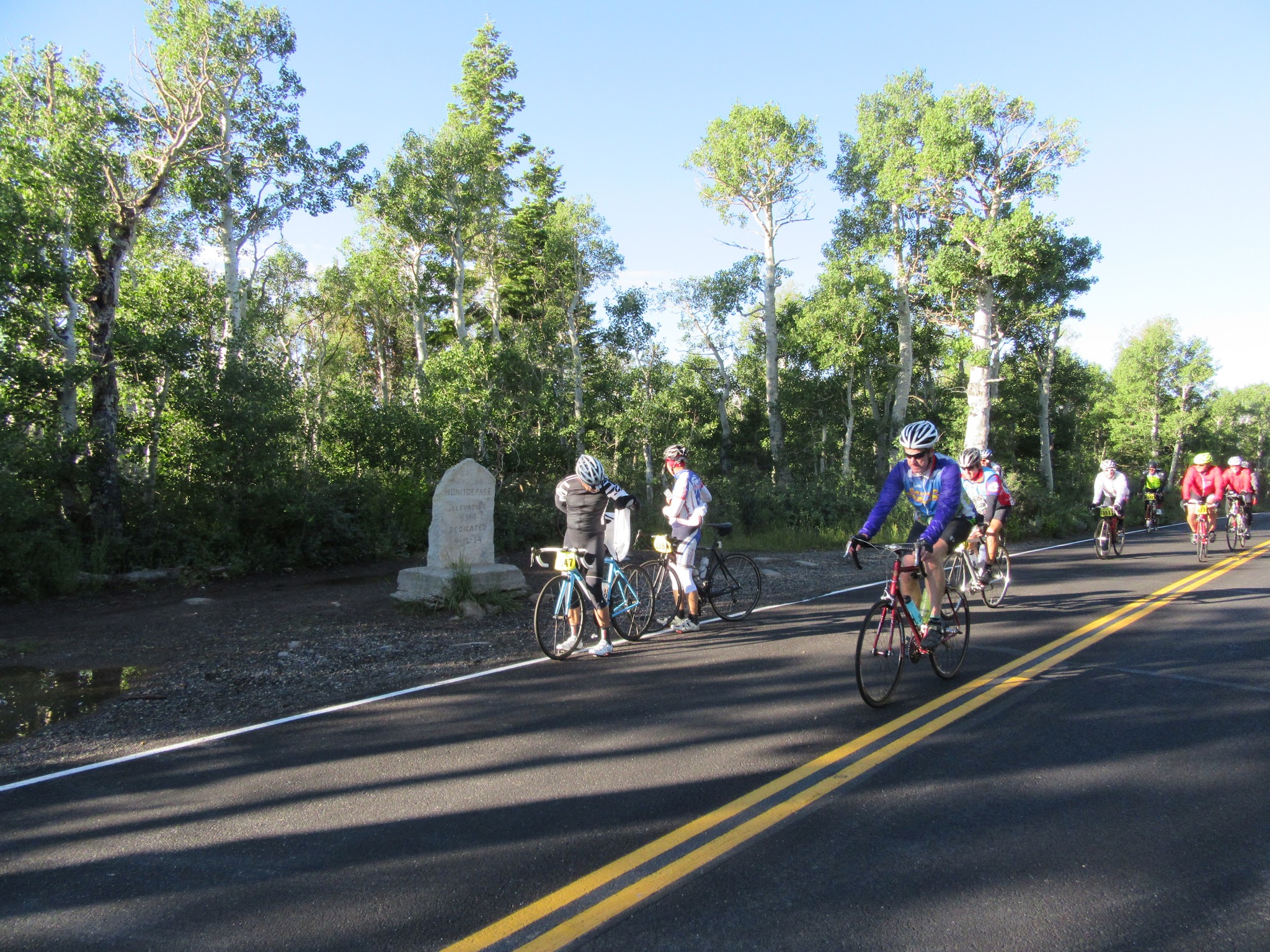Monitor Pass East Cyclists on bikes next to stone sign during Monitor Pass East portion of death ride
