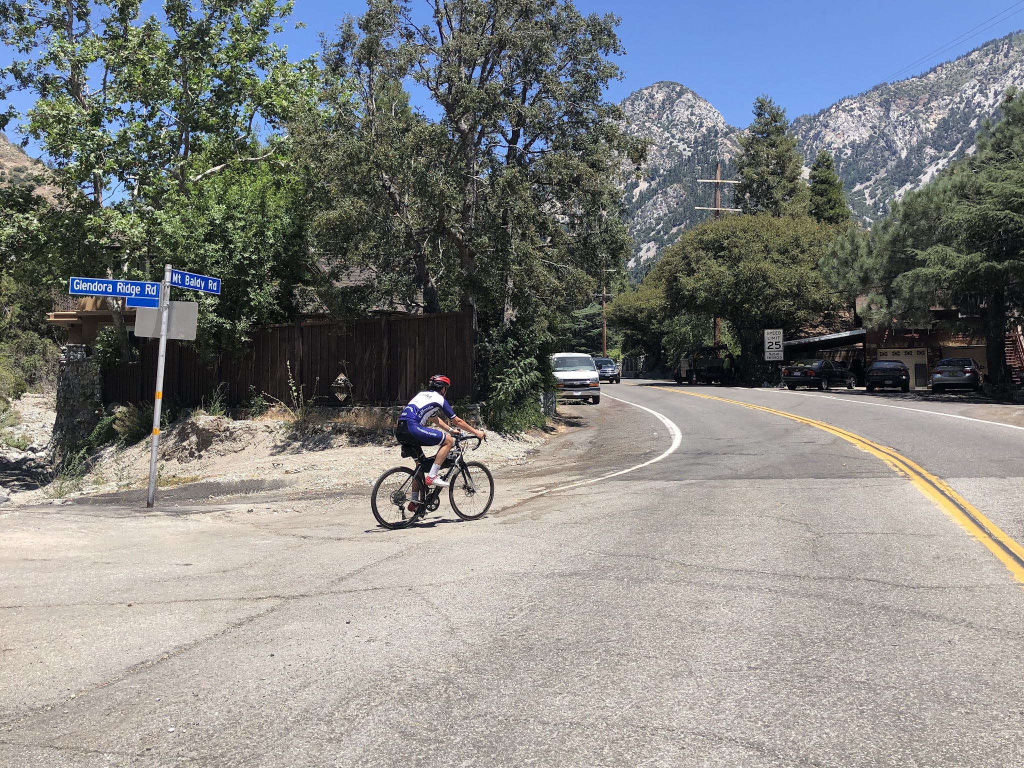 Cyclist at stop sign at Mt Baldy Village coming from Glendora Mountain Road