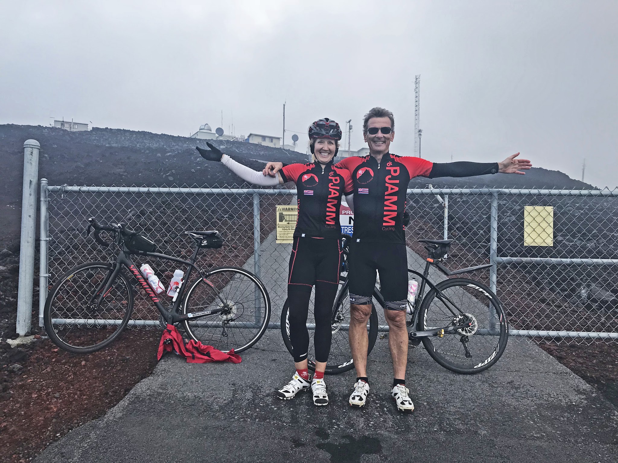 Bicycle climb Mauna Loa Volcano - Bruce Hamilton and Stacy Topping cyclists at Mauna Loa Observatory with bikes