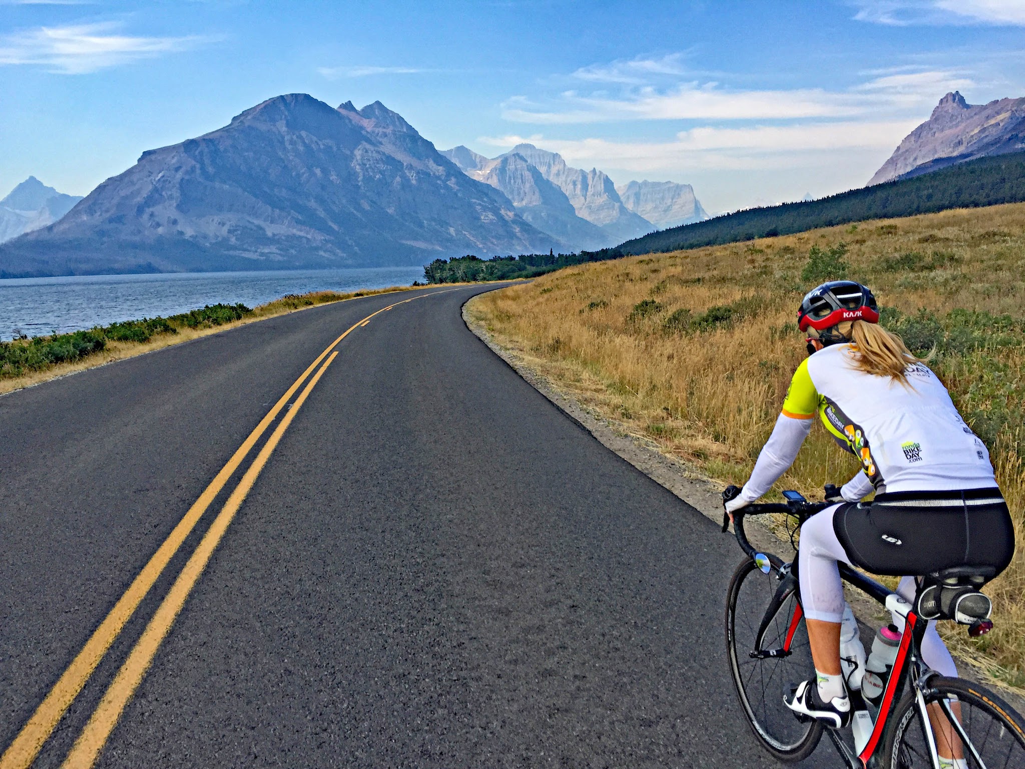 Cycling Logan Pass East, Going-to-the-Sun Road, Glacier National Park - cyclist riding along two-lane road next to Saint Mary Lake