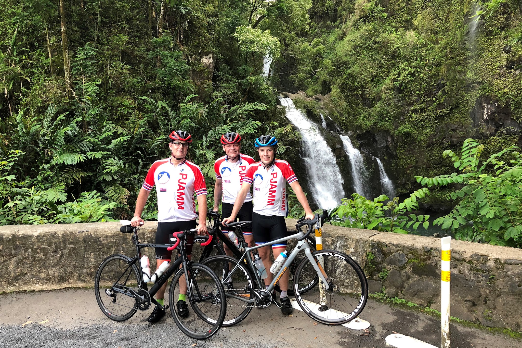 Cycling the Road to Hana - 3 PJAMM cyclists with bikes at waterfall