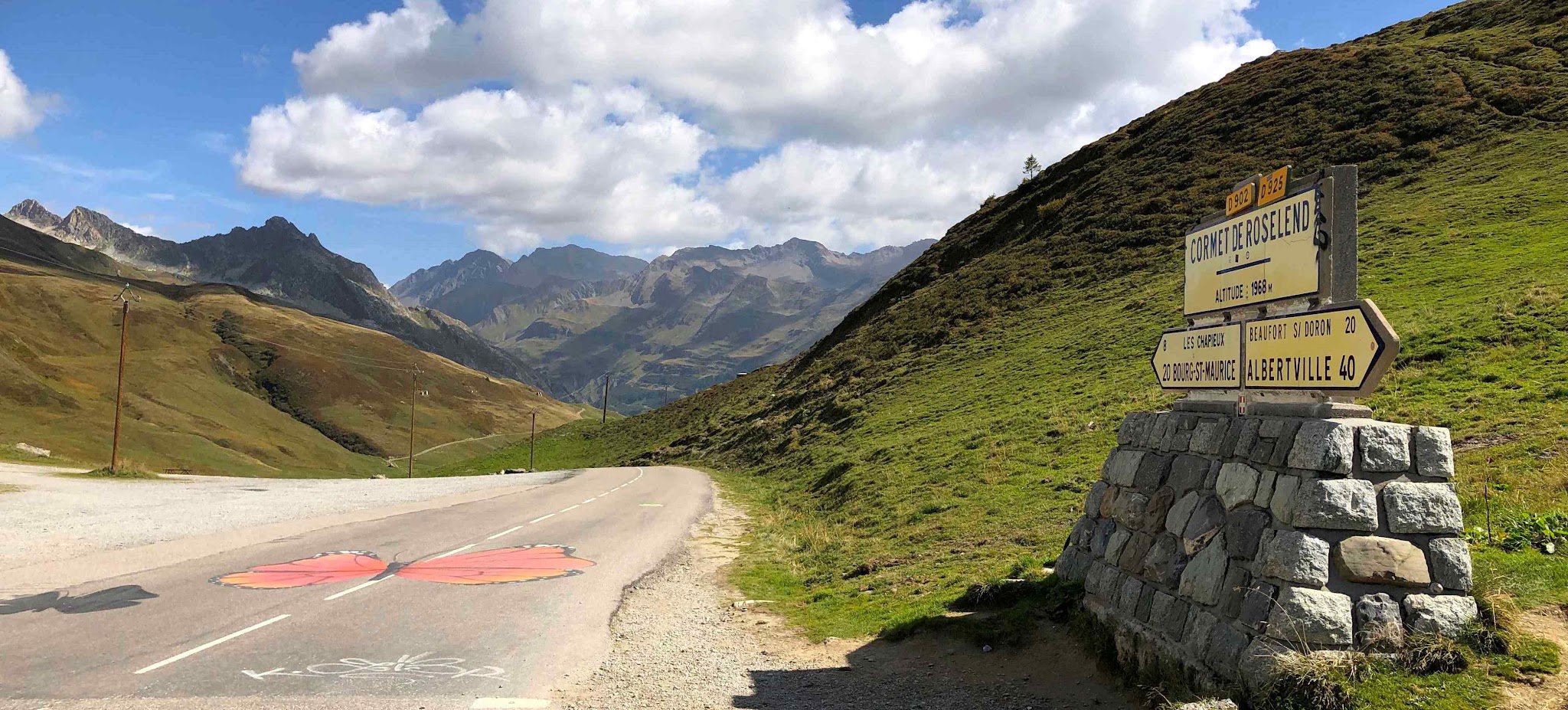 Cycling Cormet de Roselend - summit sign and road, mountains
