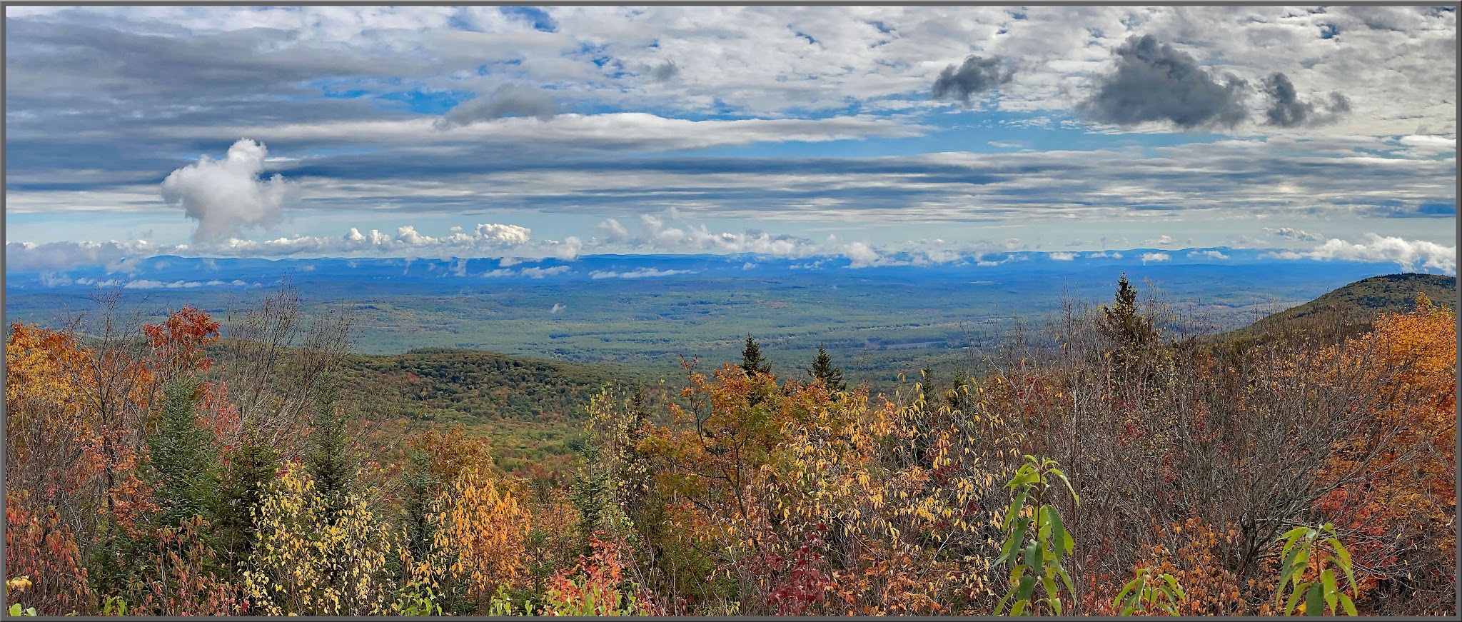 Cycling Kearsarge Mountain Road, New Hampshire - panoramic view looking down hillside covered in fall foliage