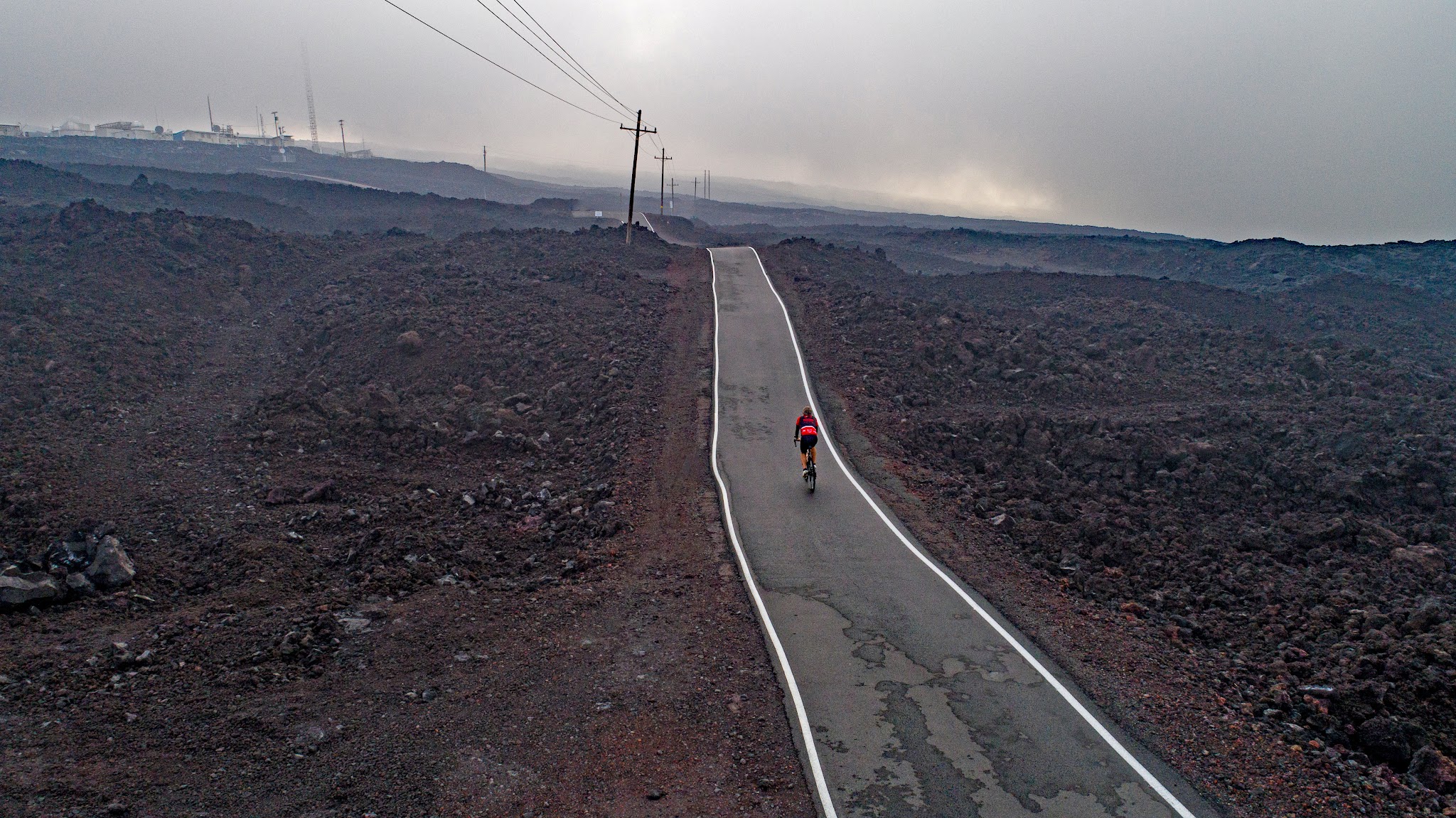 Climbing Mauna Loa by bike - Mauna Loa Observatory Road - roadway and telephone poles with lava field