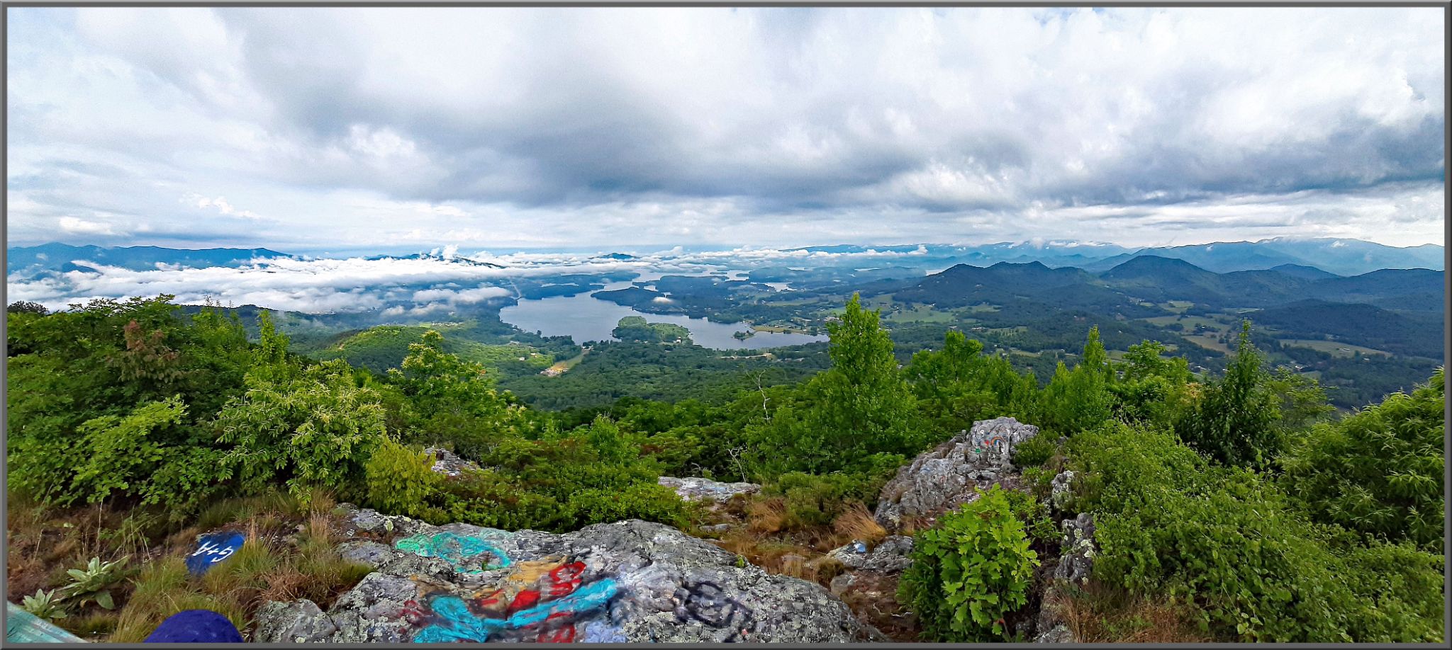 panoramic view looking down mountainside, graffitied rocks