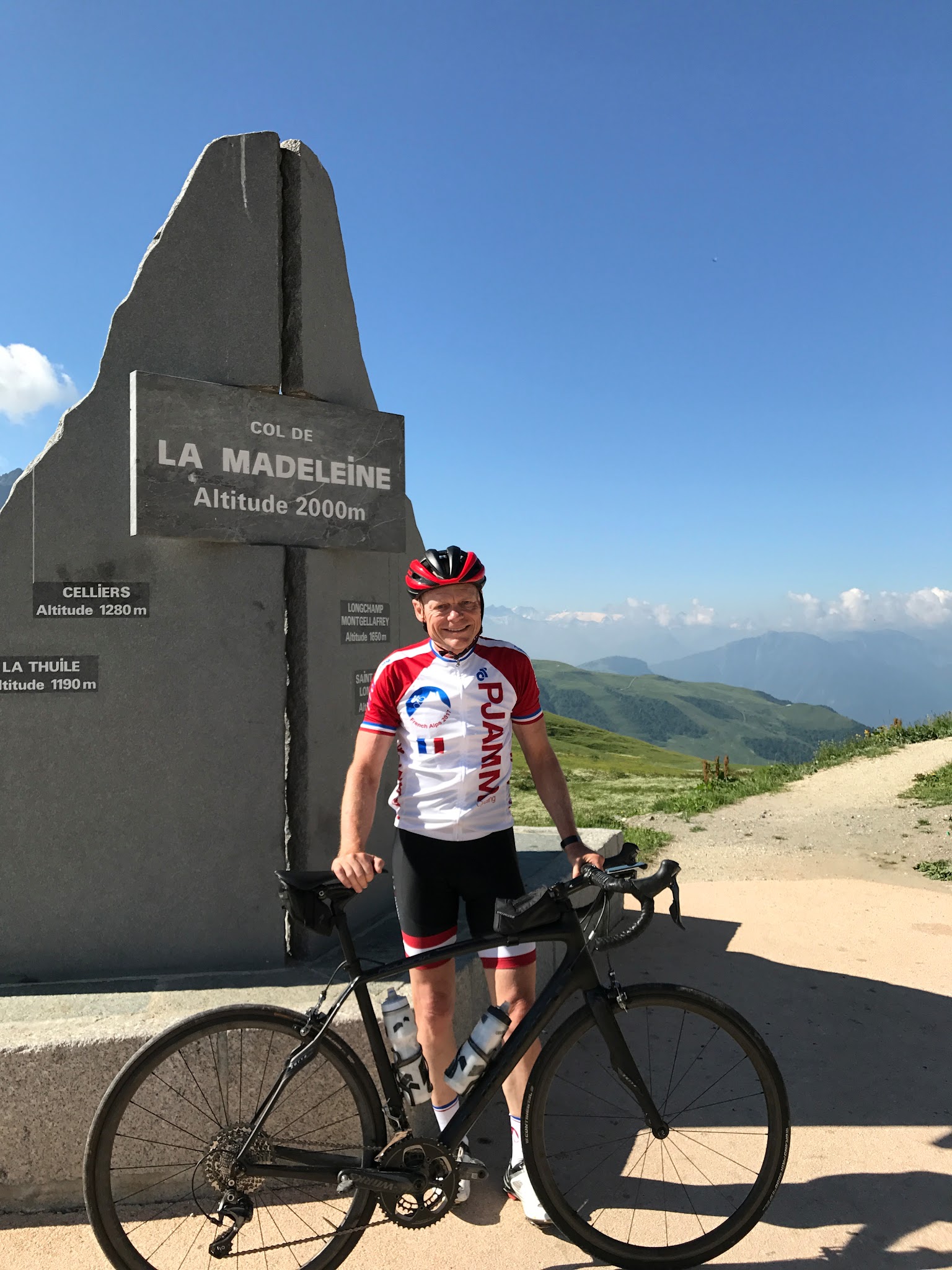 Cycling the greatest climbs - Col de Madeleine from La Chambre  - cyclists with bike at col monument