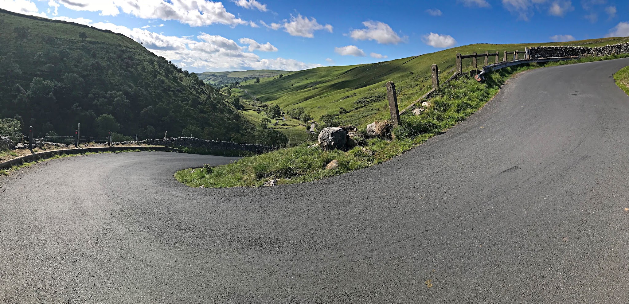 Cycling Park Rash - sharp u-shaped turn up the hillside, newly paved one-lane road, surrounded by pastureland