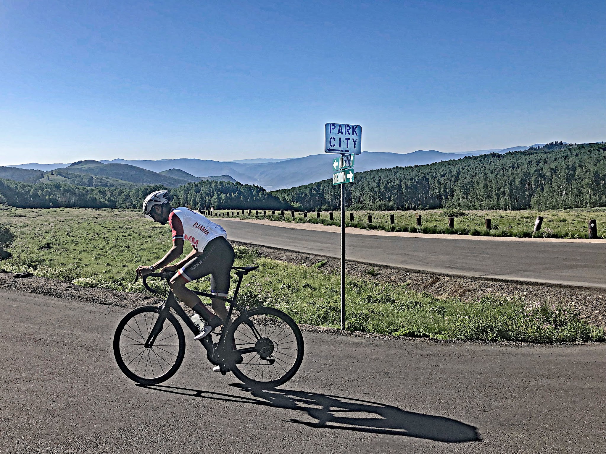 Cycling Empire Pass from Midway - cyclist on bike, Park City sign