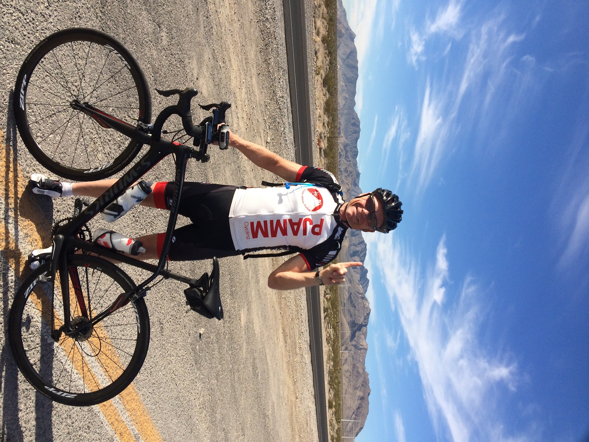 John Johnson PJAMM Cycling with bike on Kyle Canyon Hwy 157 Mt Charleston bike climb. 
