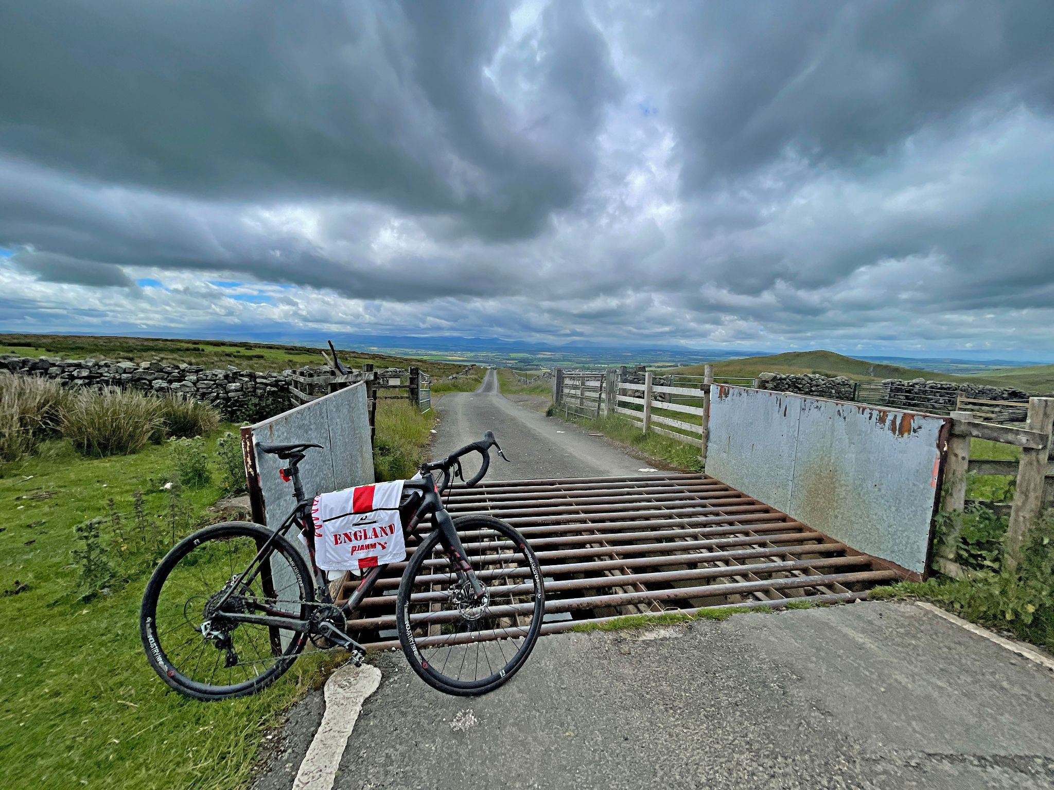 bike and PJAMM Cycling England jersey parked next to cattle guard