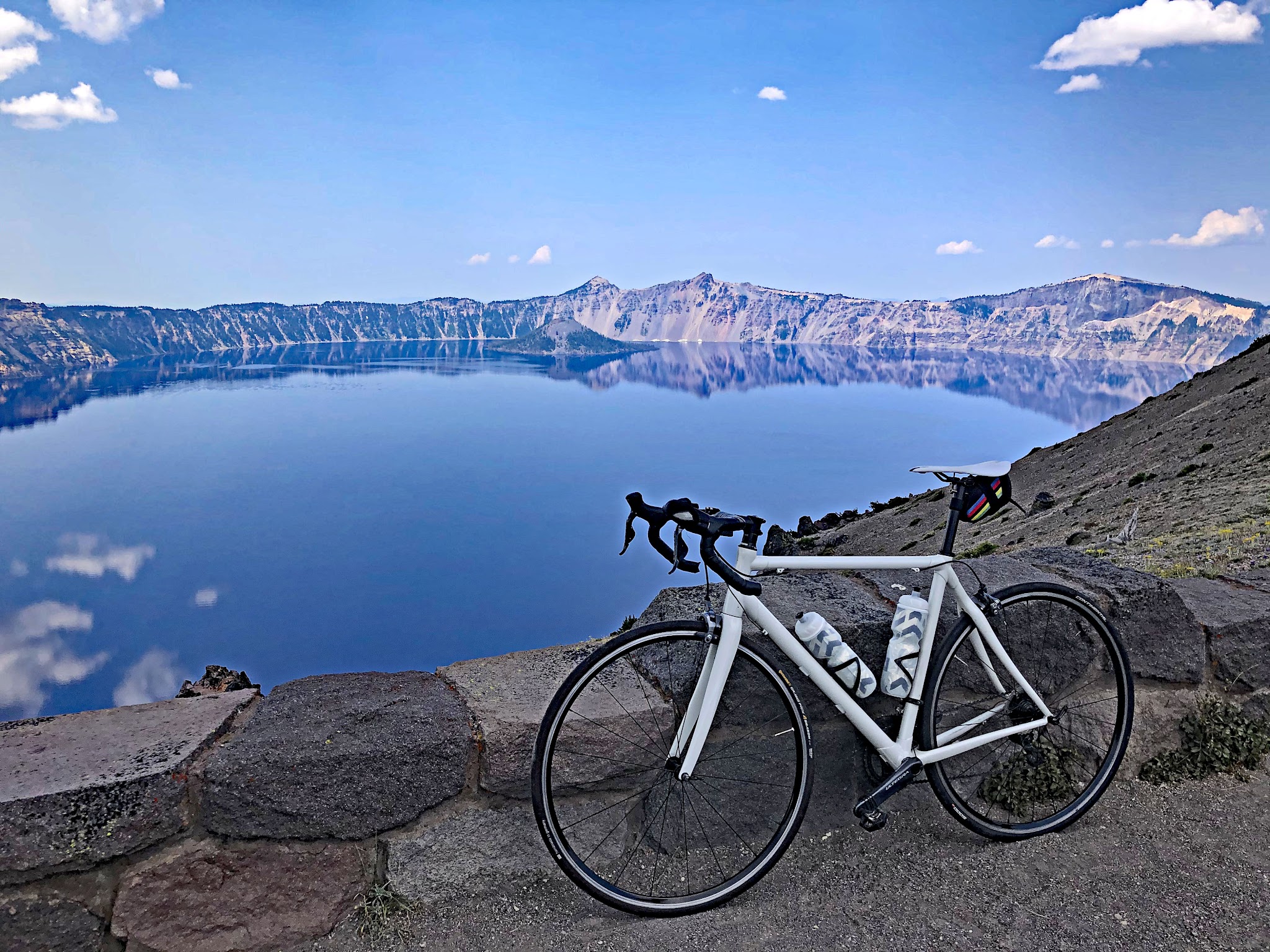 Cycling Crater Lake, Oregon, Northern Entrance - bike parked along low stone retaining wall overlooking Crater Lake