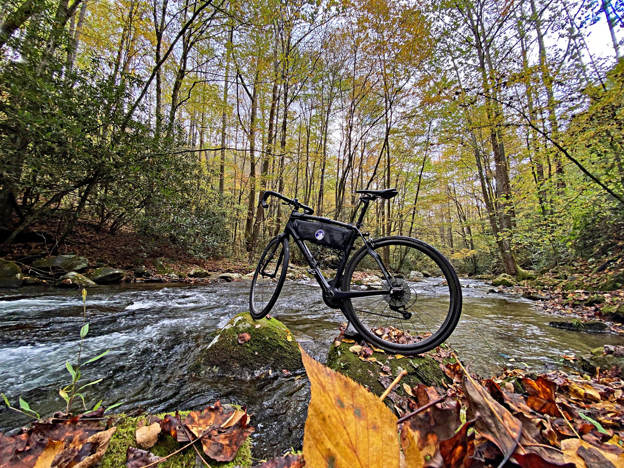 Cycling Clingmans Dome, North Carolina - bike parked along bank of Oconaluftee River, fall colors