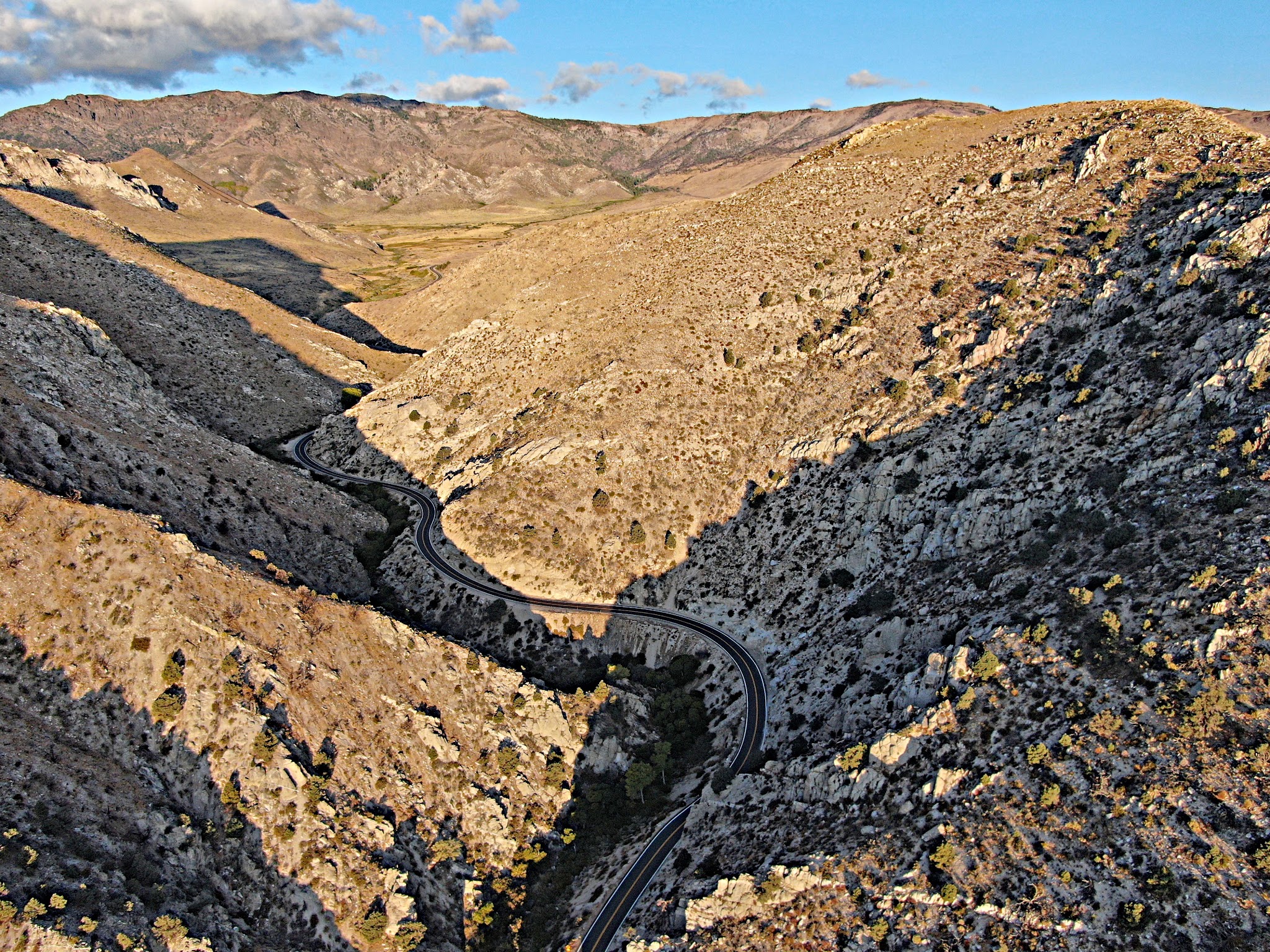 Climbing Monitor Pass East  by bicycle - Death Ride cyclists descending through canyon