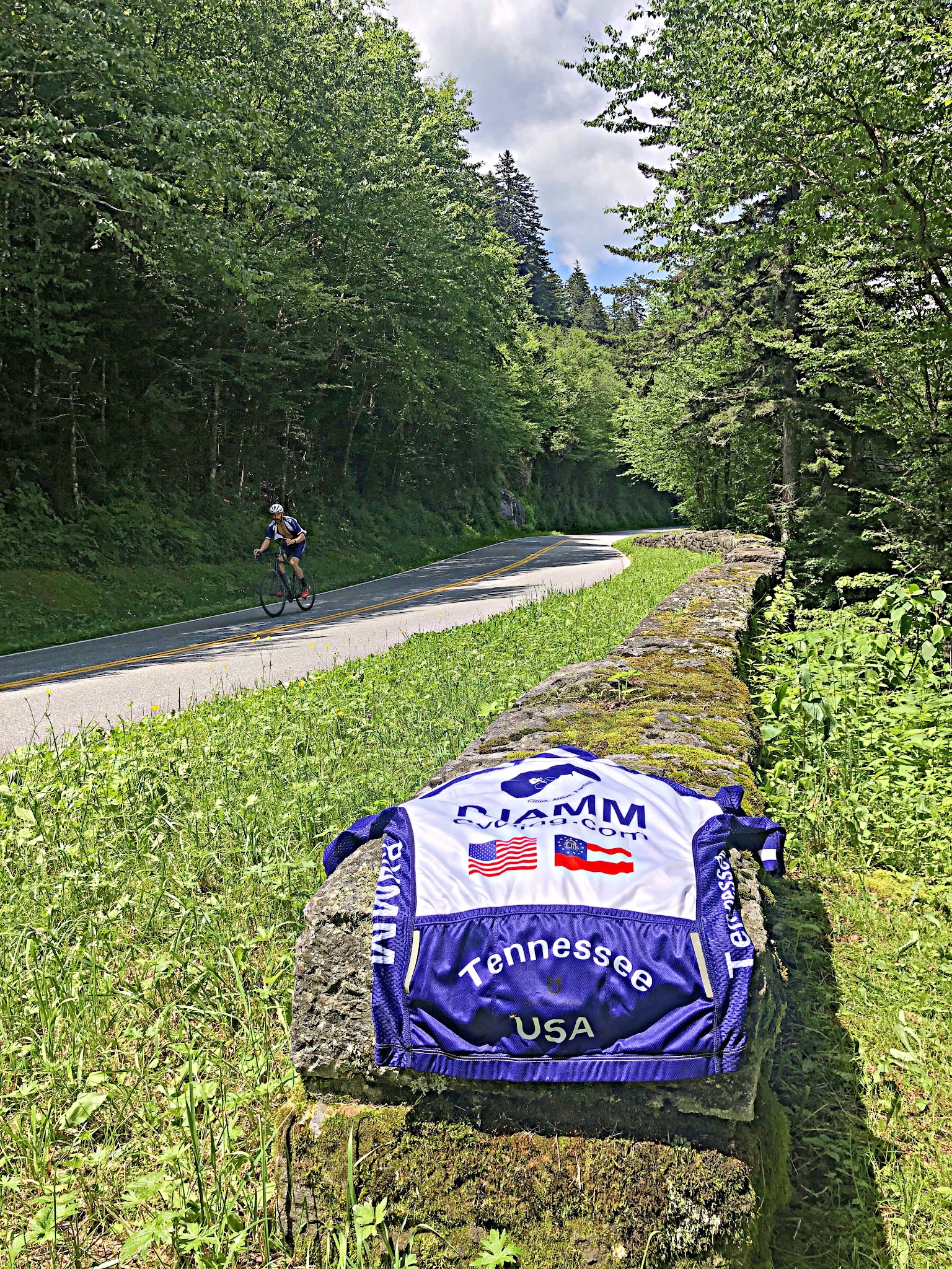 Cycling Clingmans Dome, North Carolina - PJAMM Cycling jersey draped over rock on roadside, cyclist riding in background