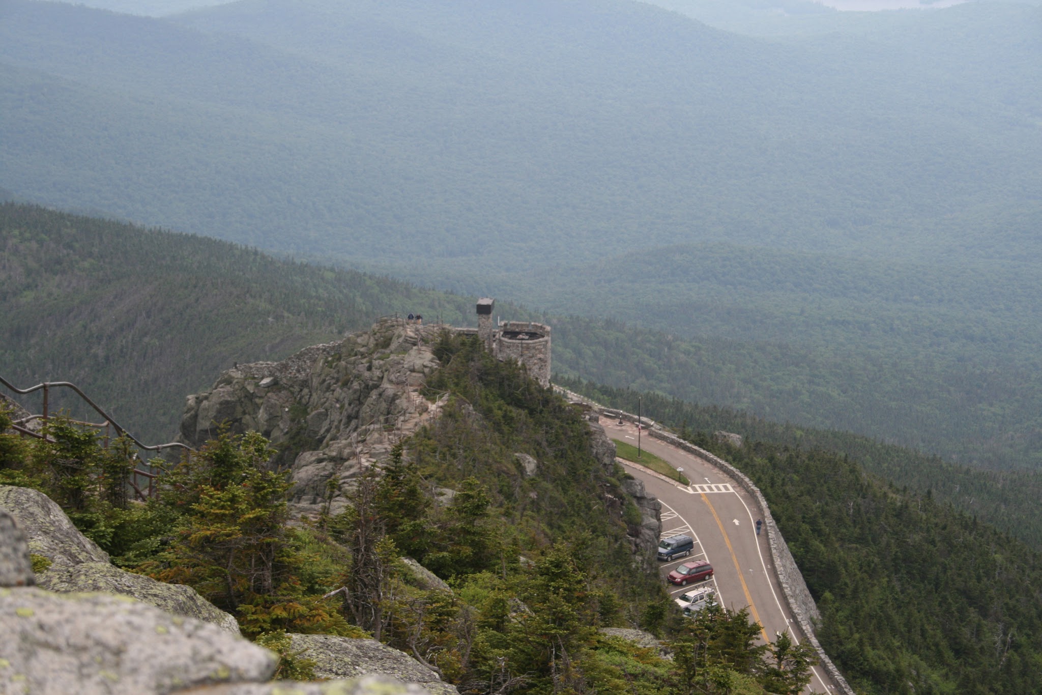 Cycling Whiteface Mountain by bike - view from above of road leading up to small stone castle at the summit of Whiteface Mountain