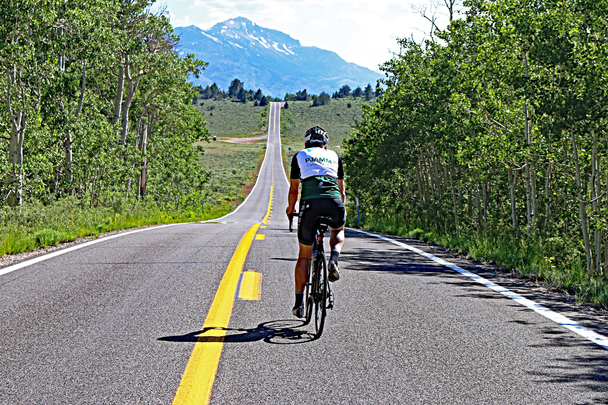 Cycling Monitor Pass East  - bicyclist riding west as the pass - roadway and mountains
