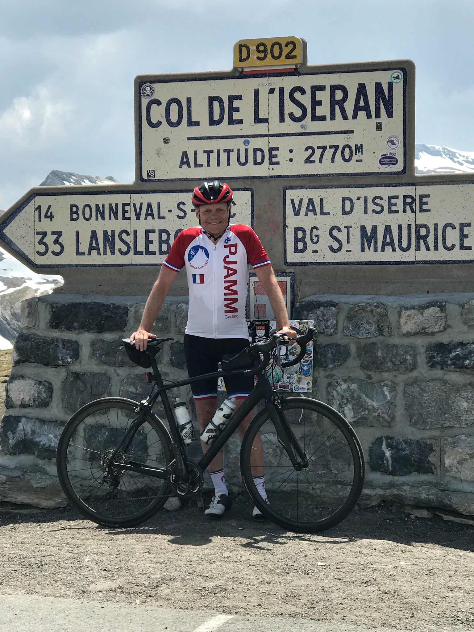 Bicycling Col de L’Iseran from Bonneval-sur-Arc John Johnson PJAMM cycling with bike at col sign