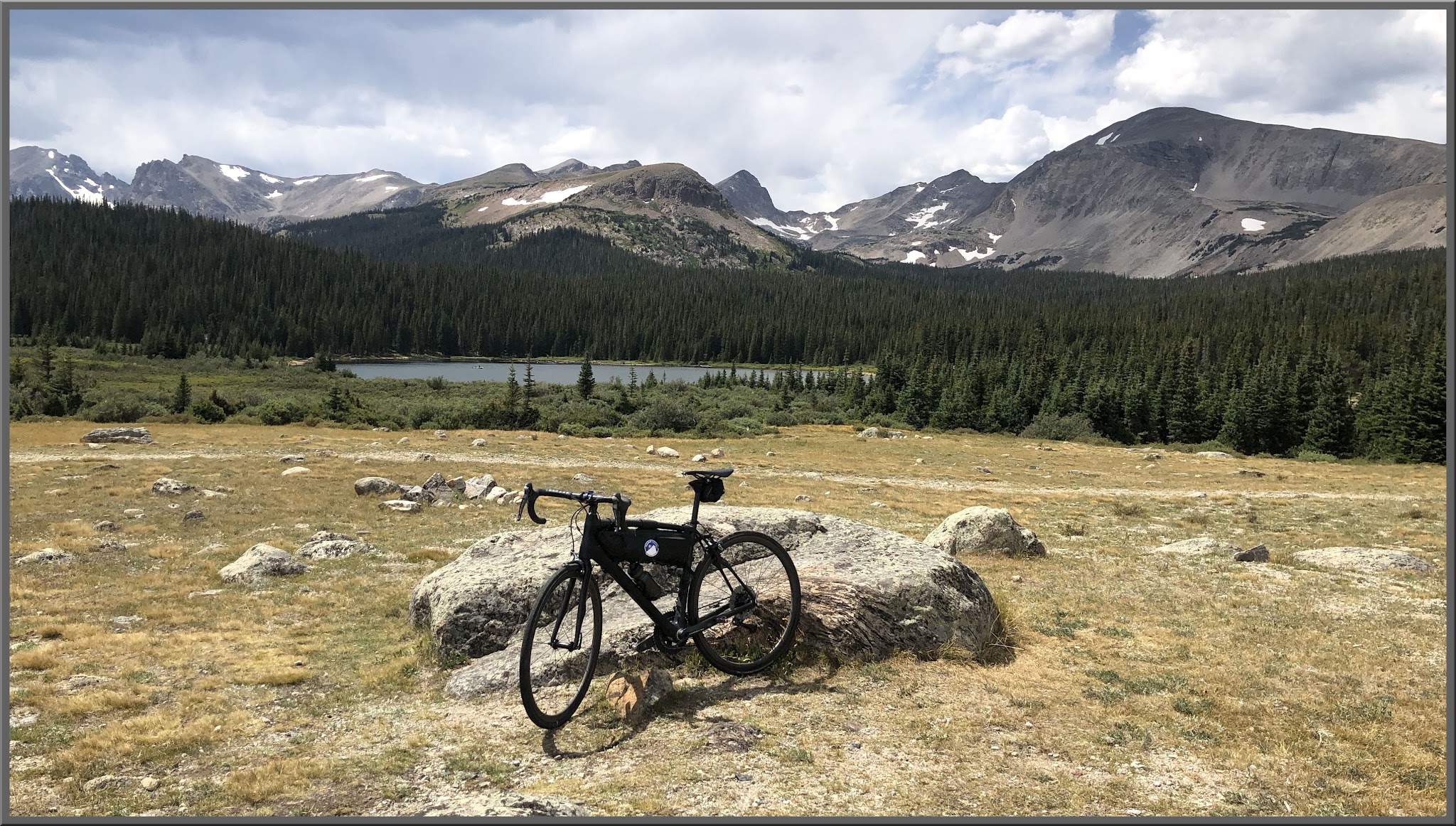 Cycling Left Hand Canyon, Boulder, Colorado - bike parked against rock formation in the middle of a valley in front of a lake, surrounded by mountains