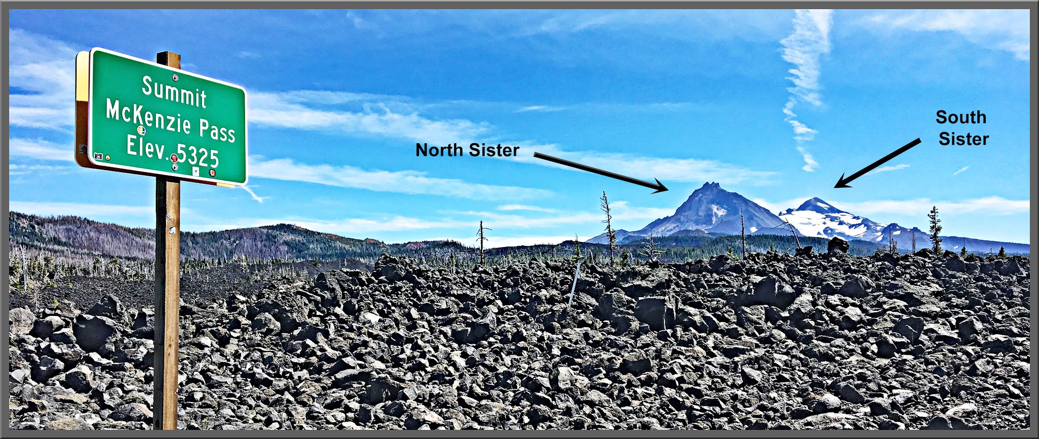 Climbing Mckenzie Pass East by bike - summit sign, north sister peak and south sister peak, lava field