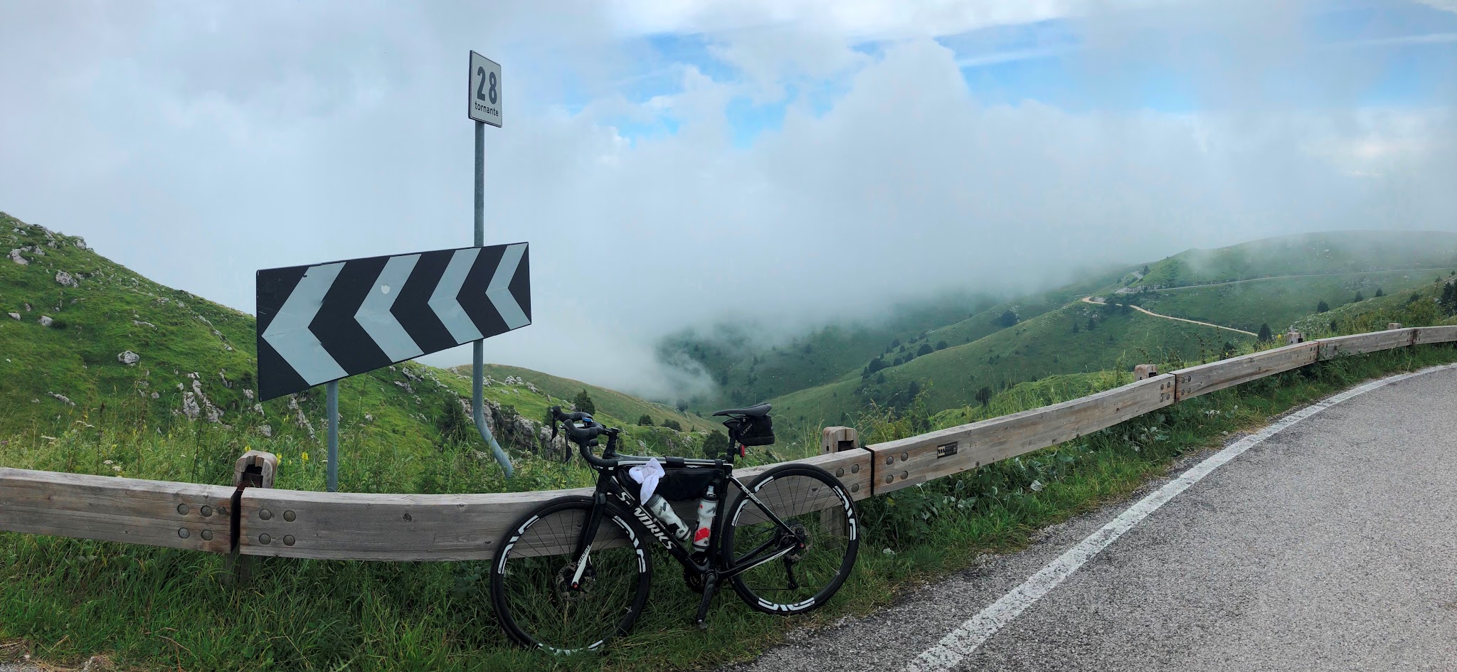 Cycling Monte Grappa from Semonzo - bike leaning against hairpin (tornante) 28 sign