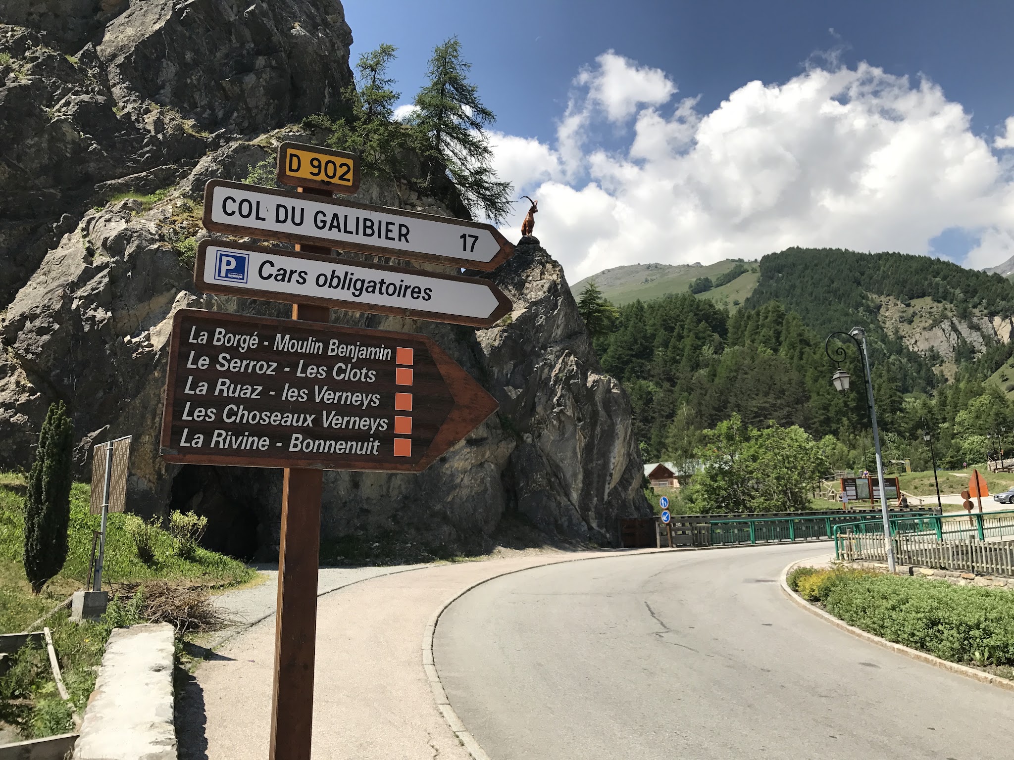 Climbing Col du Galibier - from Valloire by bike - roadway sign, roadway and elk statue in Valloire