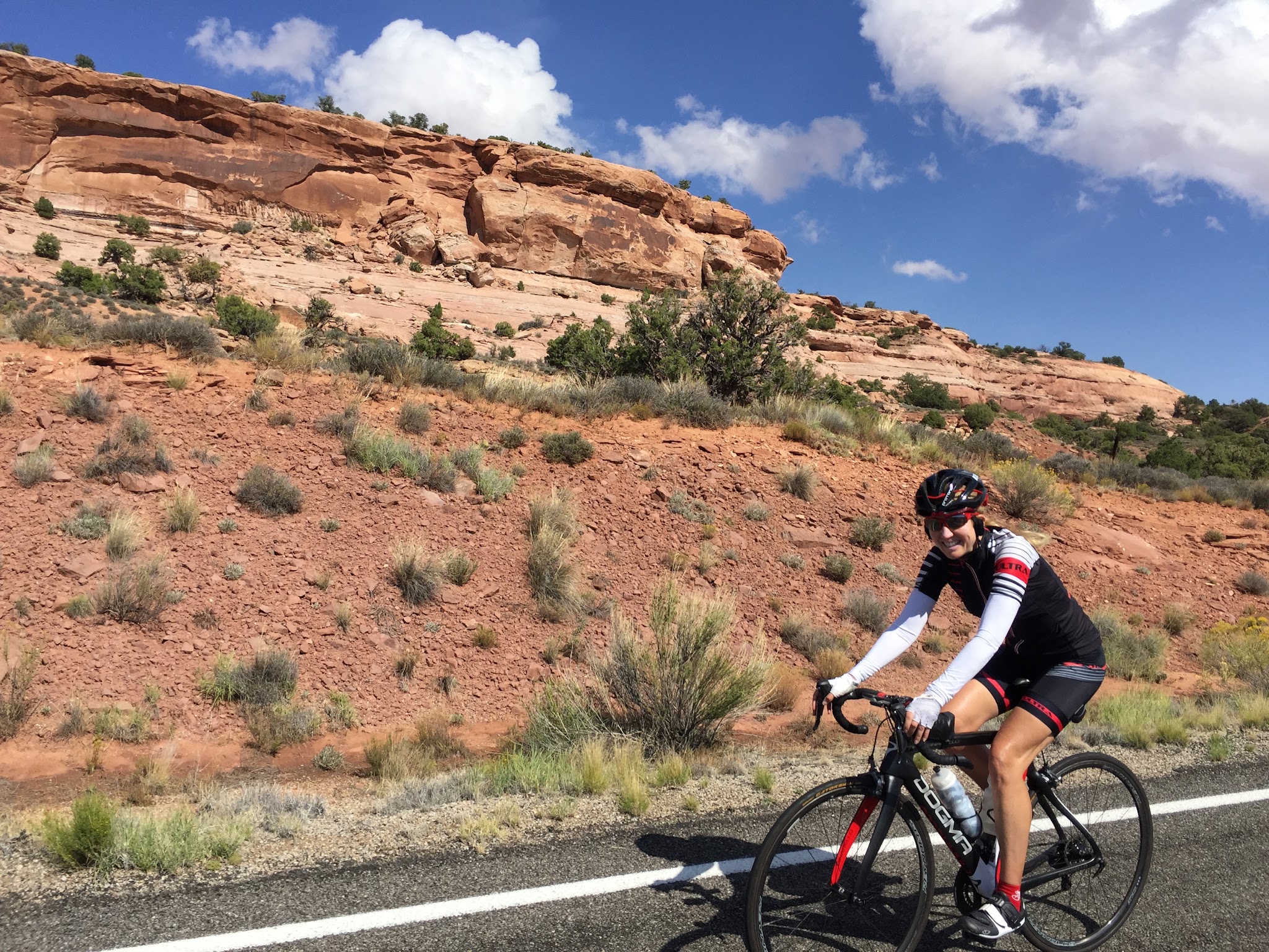Cycling Canyonlands National Park Cycling Canyonlands National Park - cyclist riding along roadway on the descent of Upheaval Dome Road