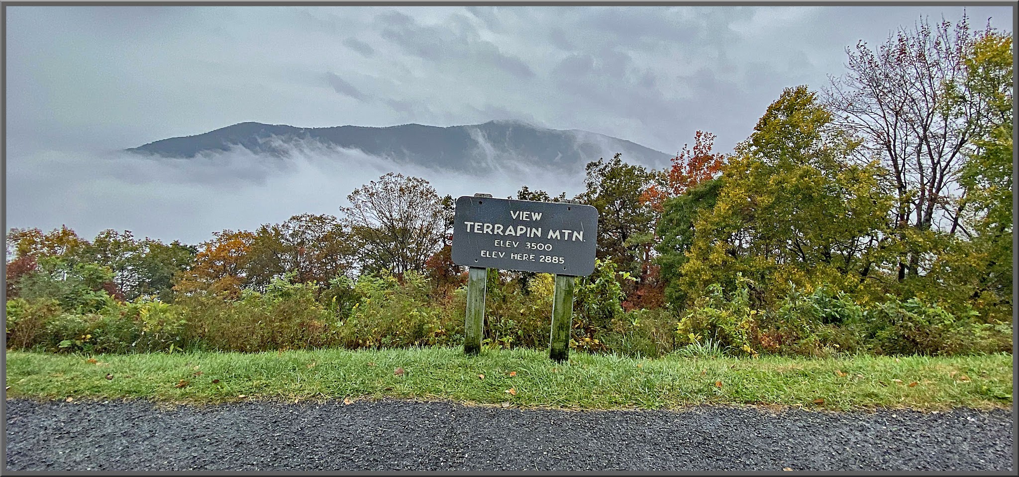 Cycling Thunder Ridge, Blue Ridge Parkway, Virginia - sign for "View Terrapin Mtn", fall foliage behind it with mountain peaking out behind fog line