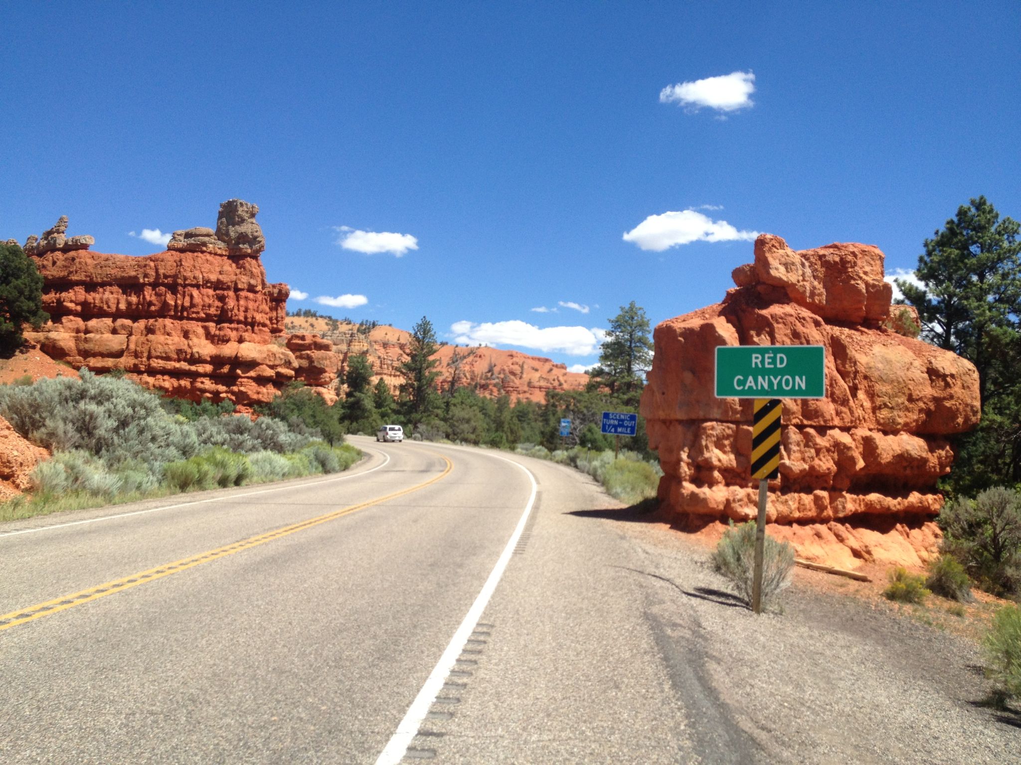 Cycling Bryce Canyon National Park, Utah - sign for Red Canyon, road travels between bright red rock formations
