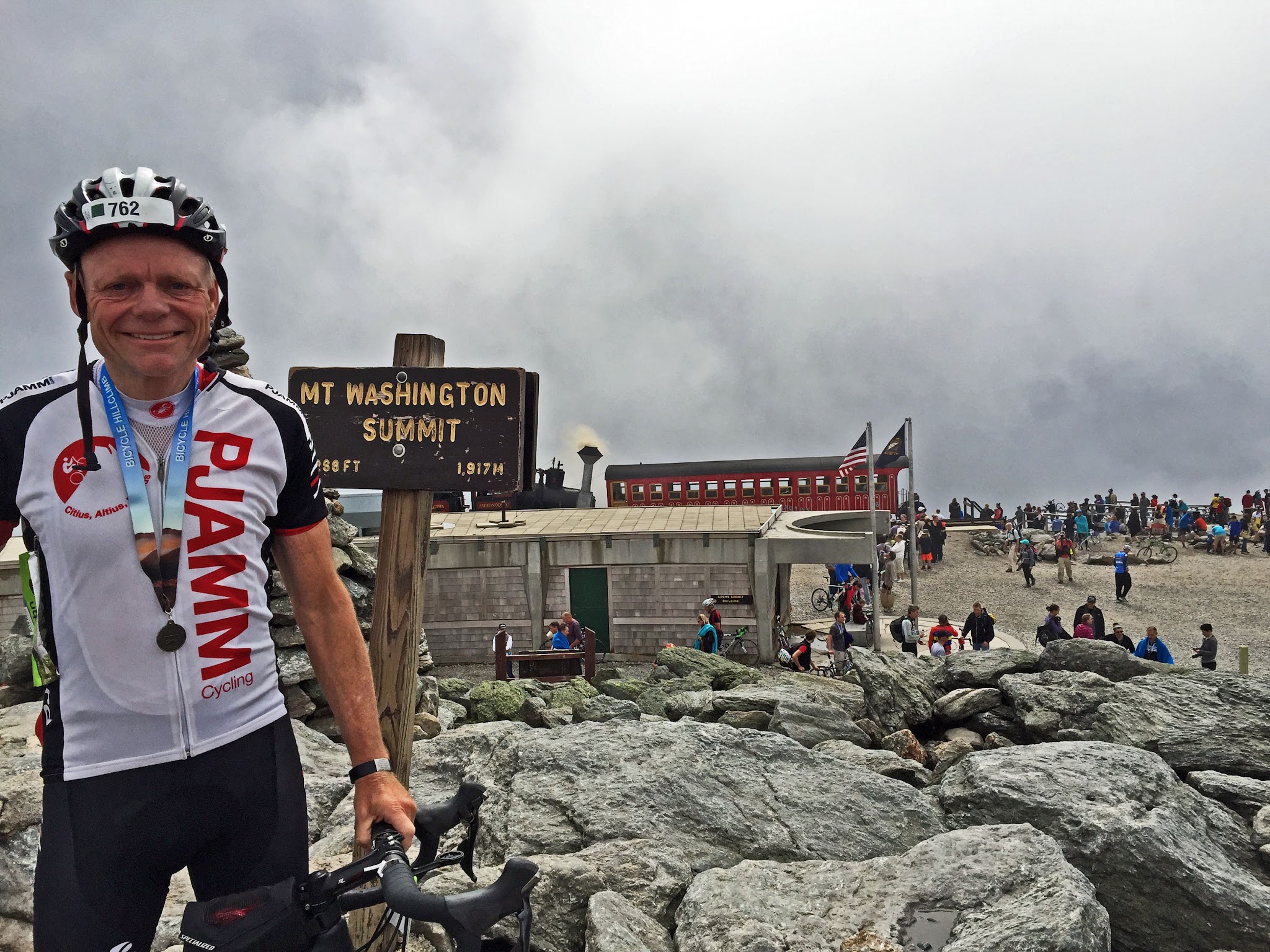 John Johnson stands at climb summit after finishing race