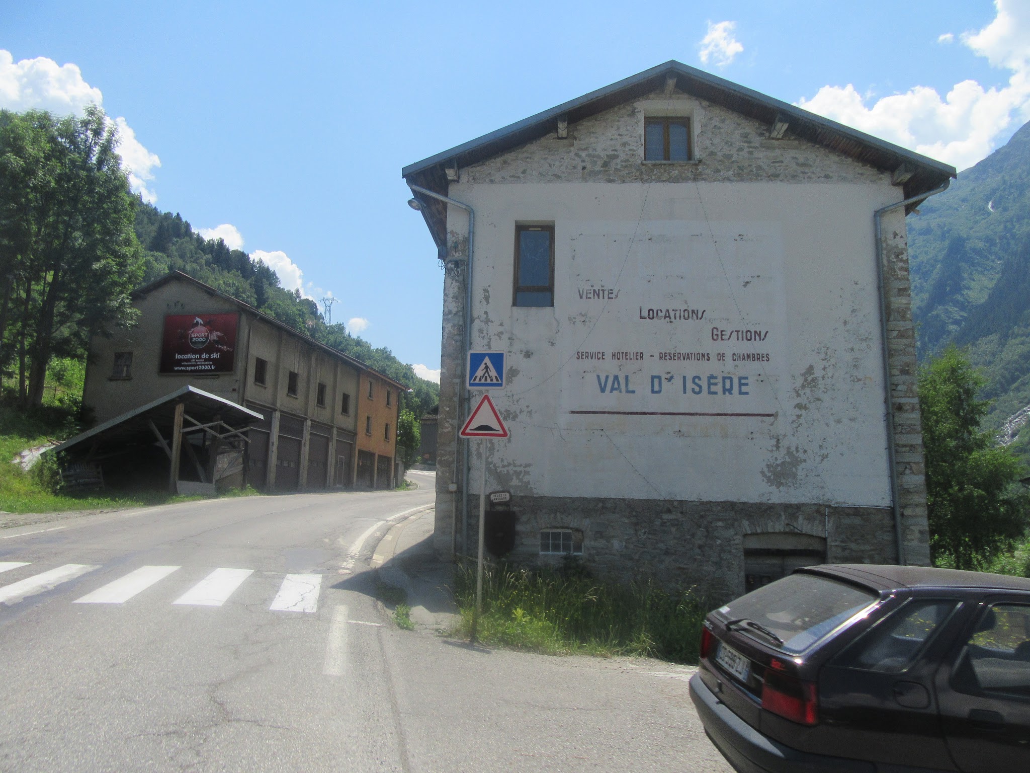 Bicycle ride of Col de L’Iseran from Val d'Isère - buildings in town and start of climb