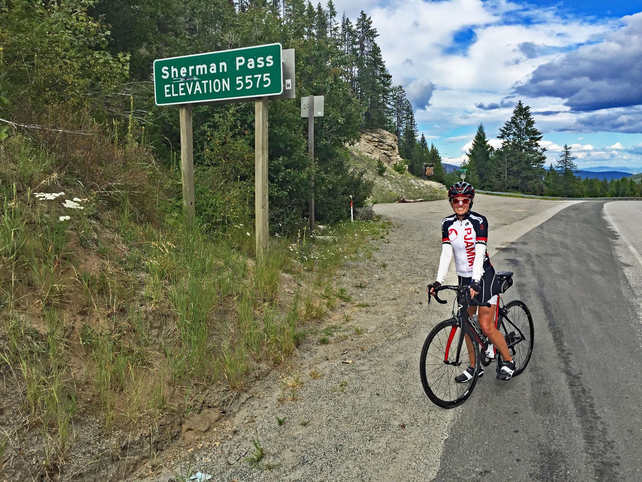 Cycling Washington Top Bike Climbs - cyclists with bike at summit sign