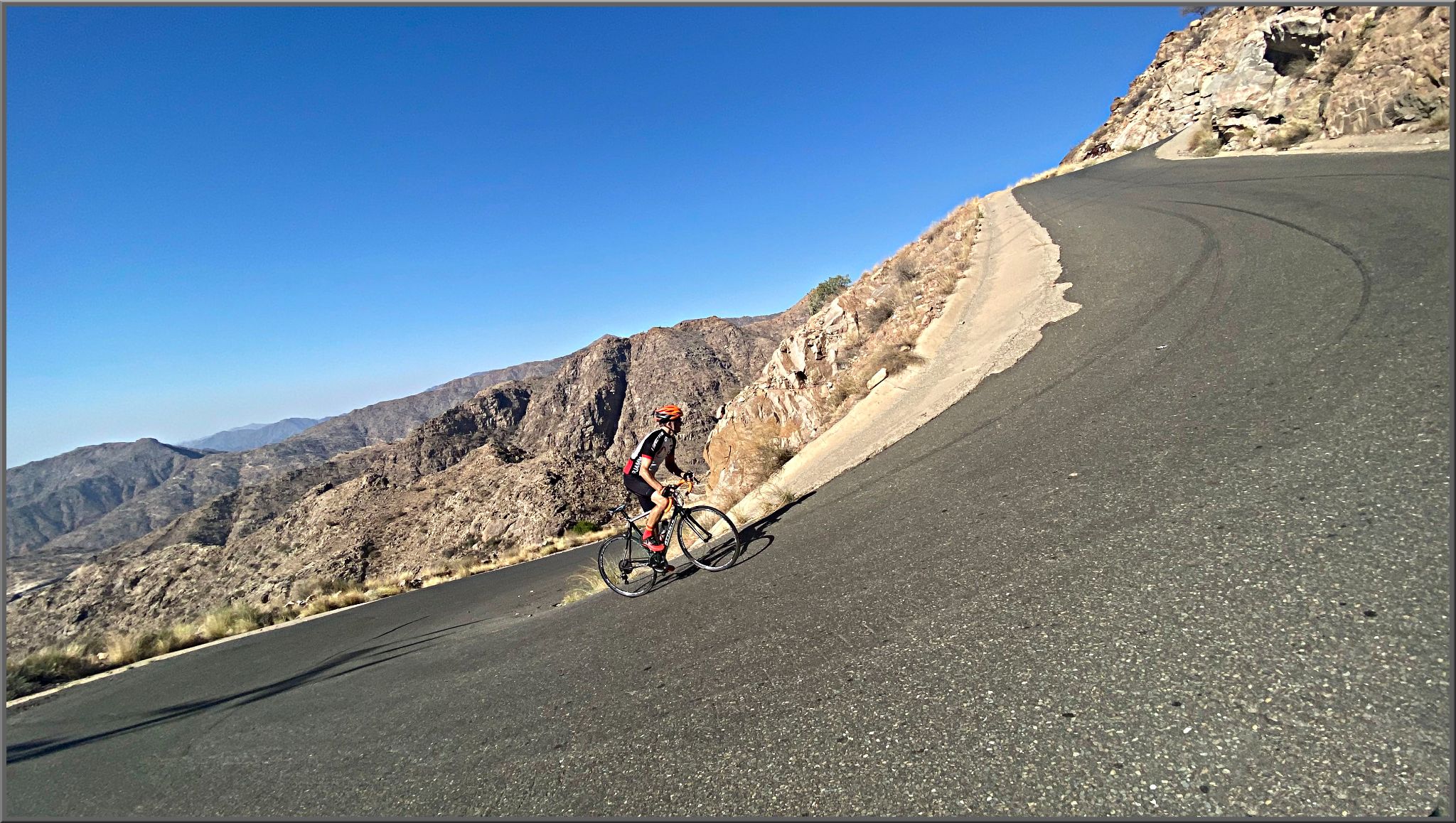 Cycling Rdom Pass, Asir Mountains, Saudi Arabia - cyclist climbs and extremely steep segment of roadway along a switchback on the Rdom Pass climb, Asir Mountains, Forst Al Ymani