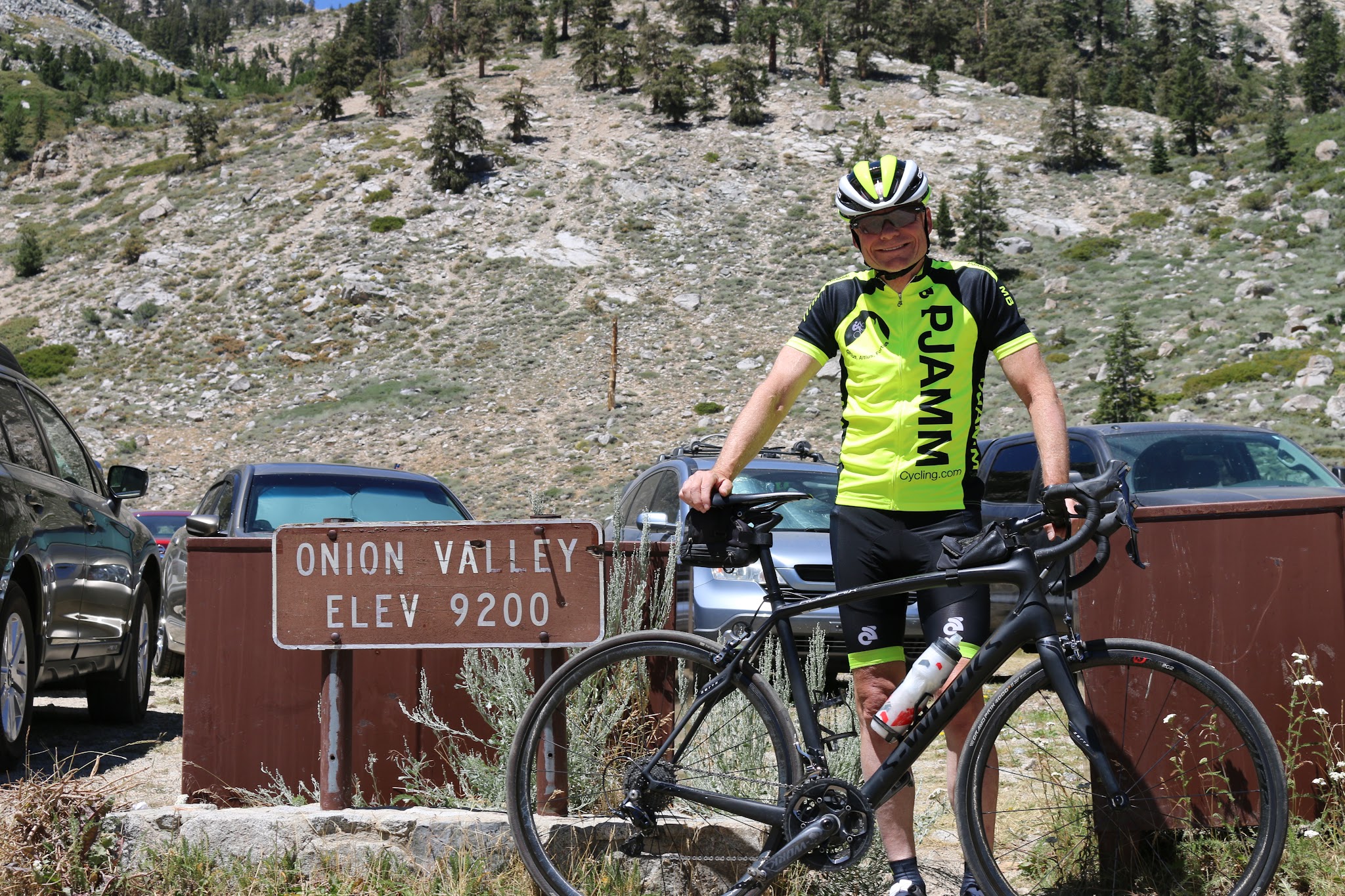 Cyclist at Onion Valley Road Elevation 9200 sign
