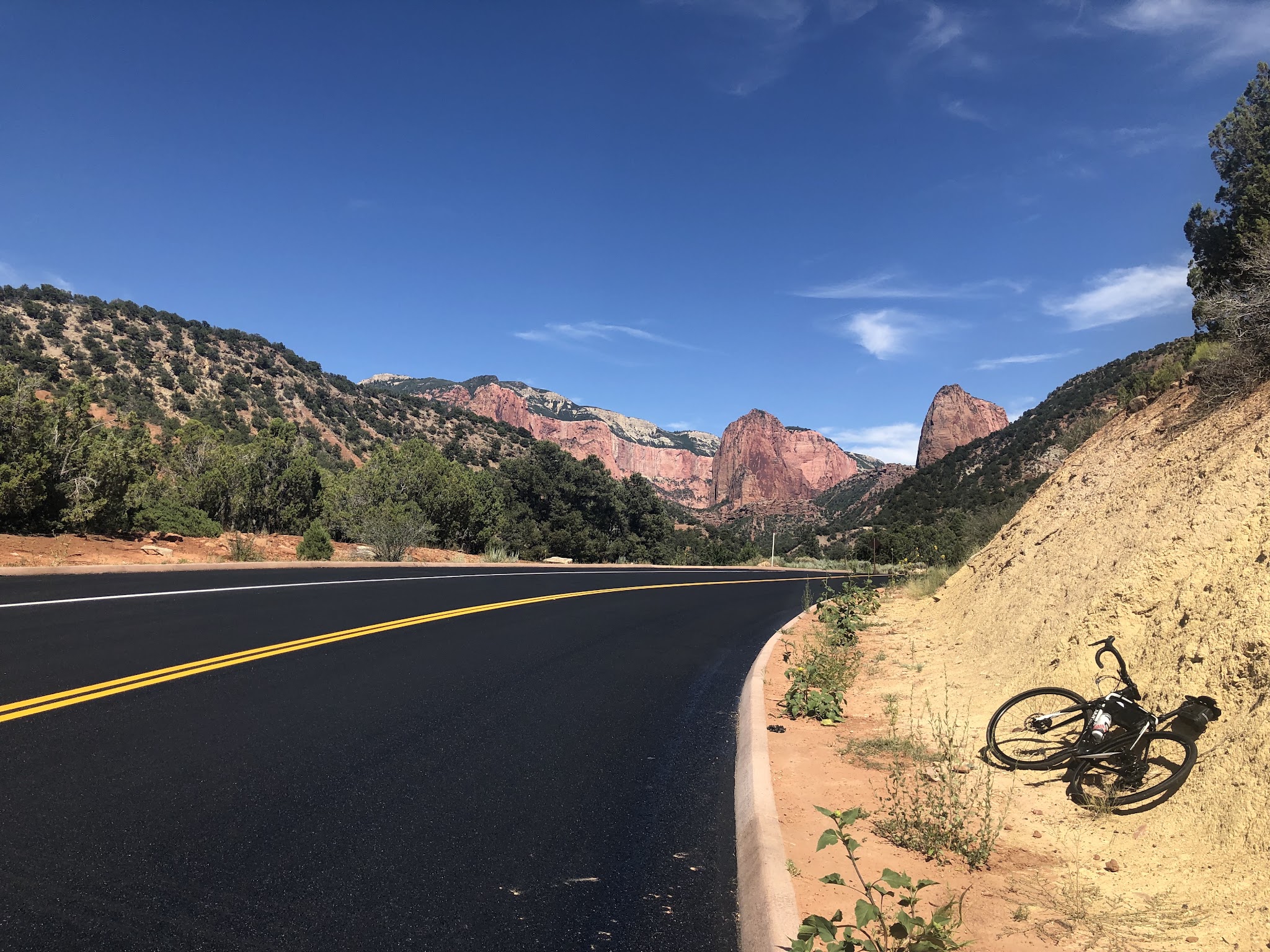 Bike climb Kolob Canyon Road - bike on side of road, road with yellow line and rock formations