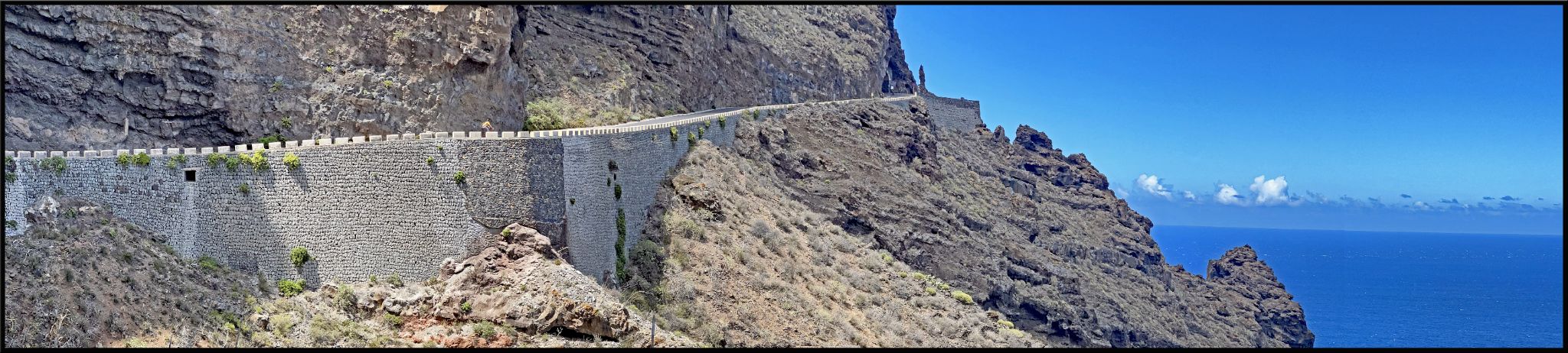 Panoramic view of road carved into rocky hillside