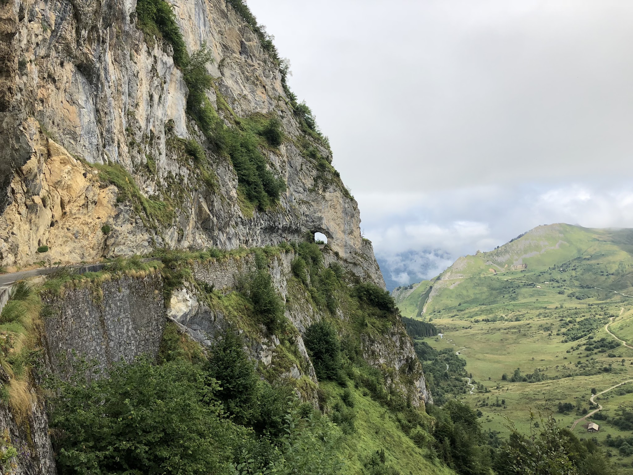 aerial drone view of tunnel carved into cliff side coming up to climb finish
